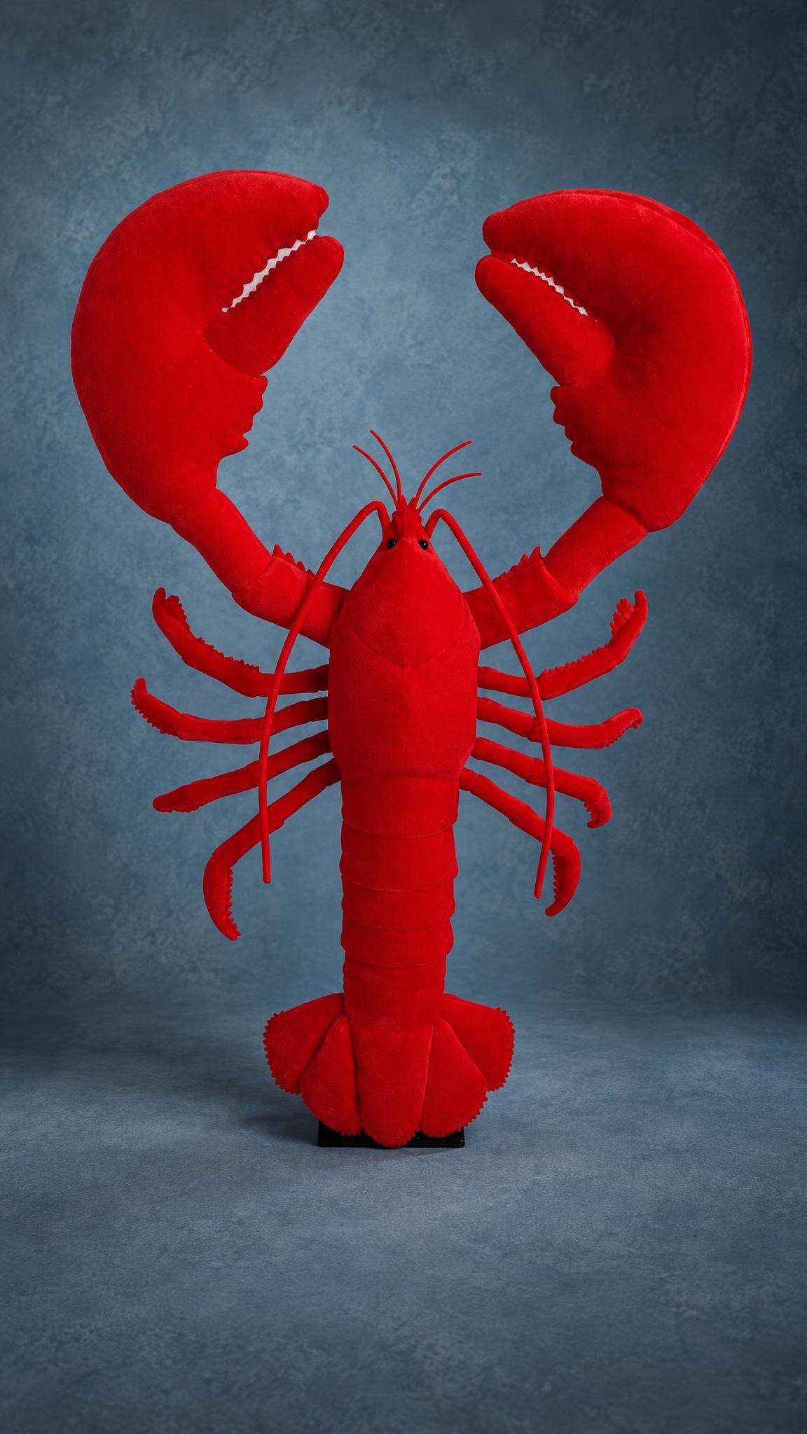 Bright red giant lobster plush standing on a black base, claws raised, a custom bar mascot sewn to order