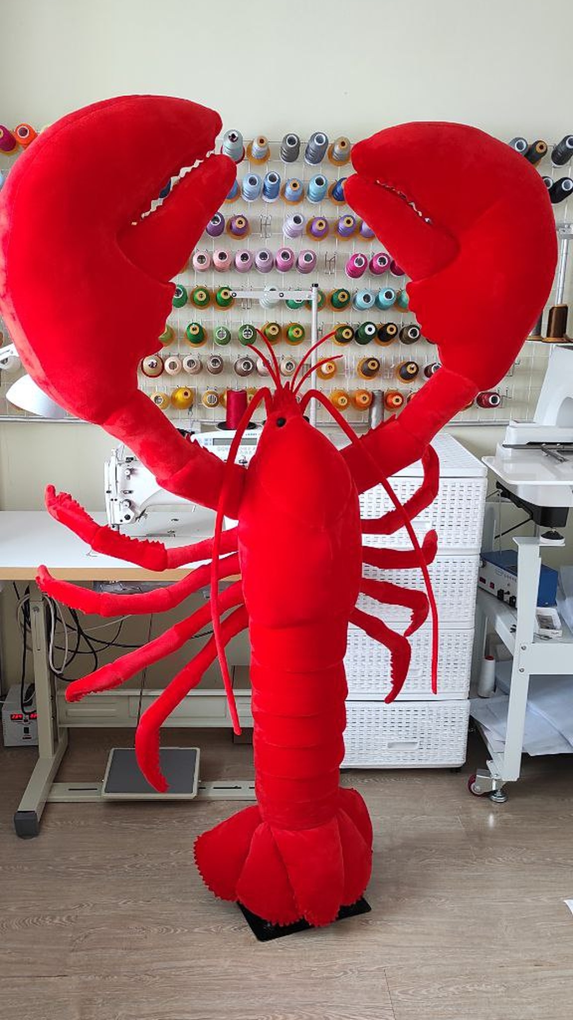 Giant lobster plush toy, about 170 cm, standing in our sewing workshop among thread spools, made to order