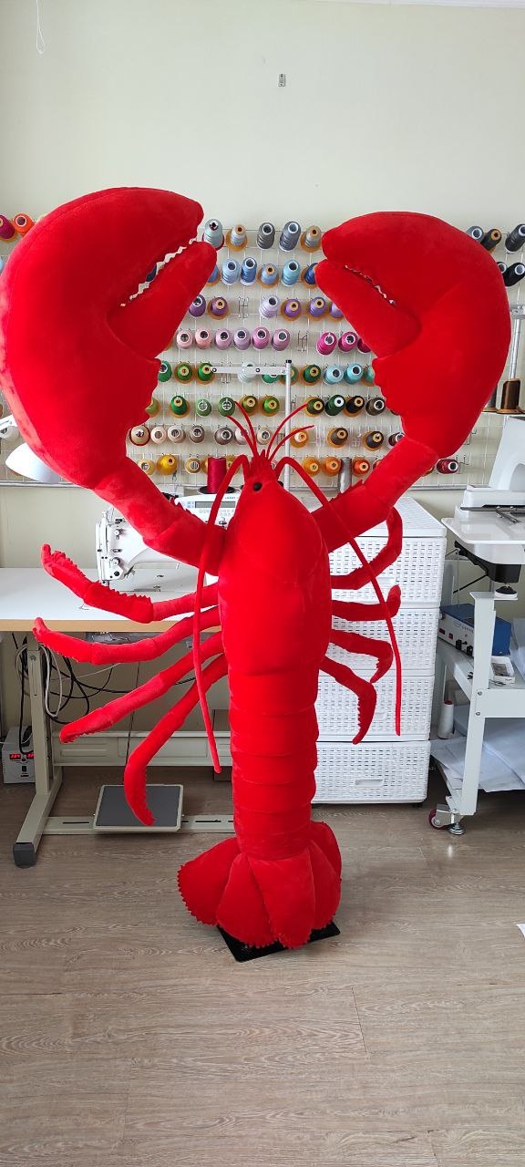 Giant lobster plush in the workshop Giant lobster plush toy, about 170 cm, standing in our sewing workshop among thread spools, made to order