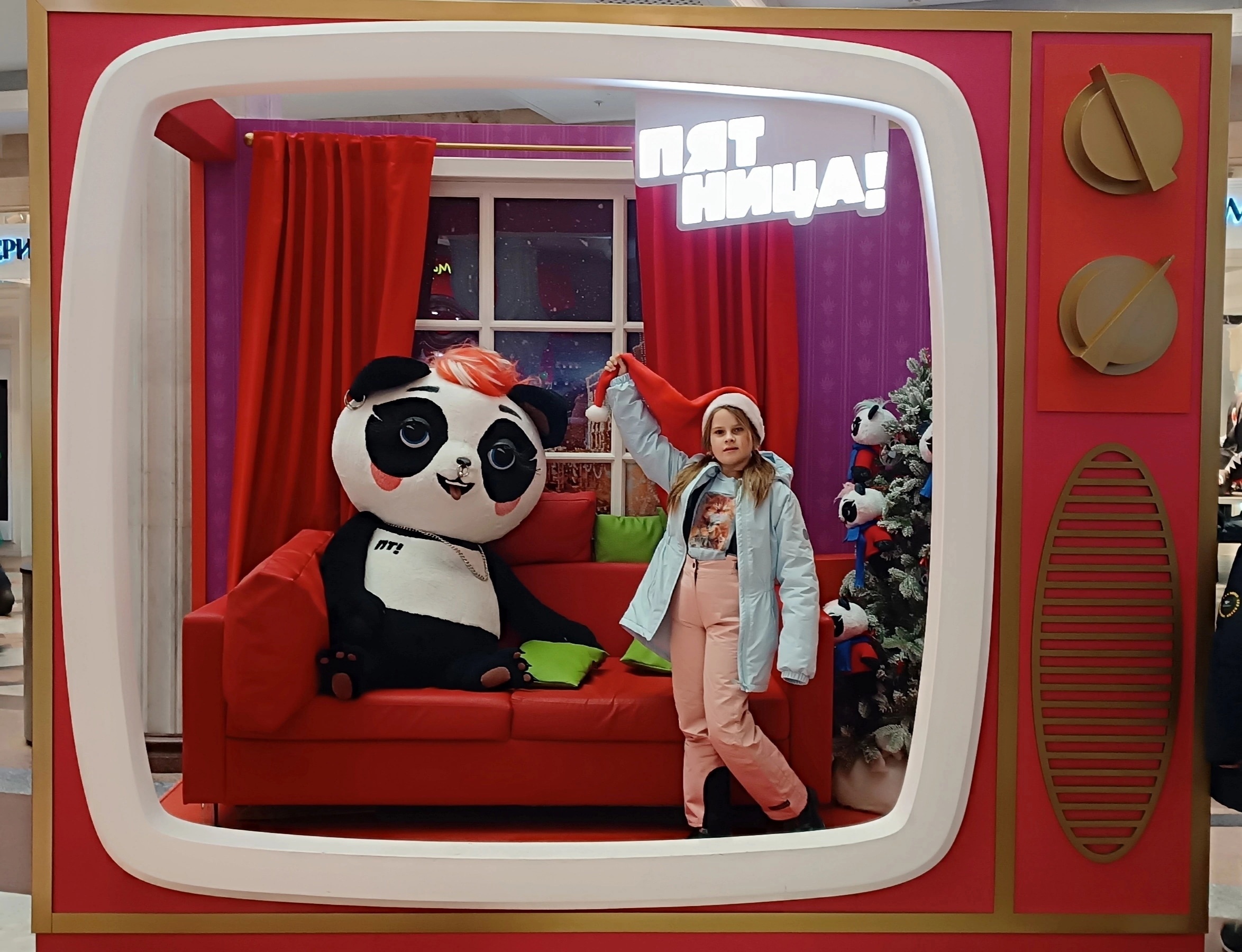 Giant panda mascot in a photo zone Giant panda mascot plush on a red sofa in a TV-set photo zone at a children's store, made to order