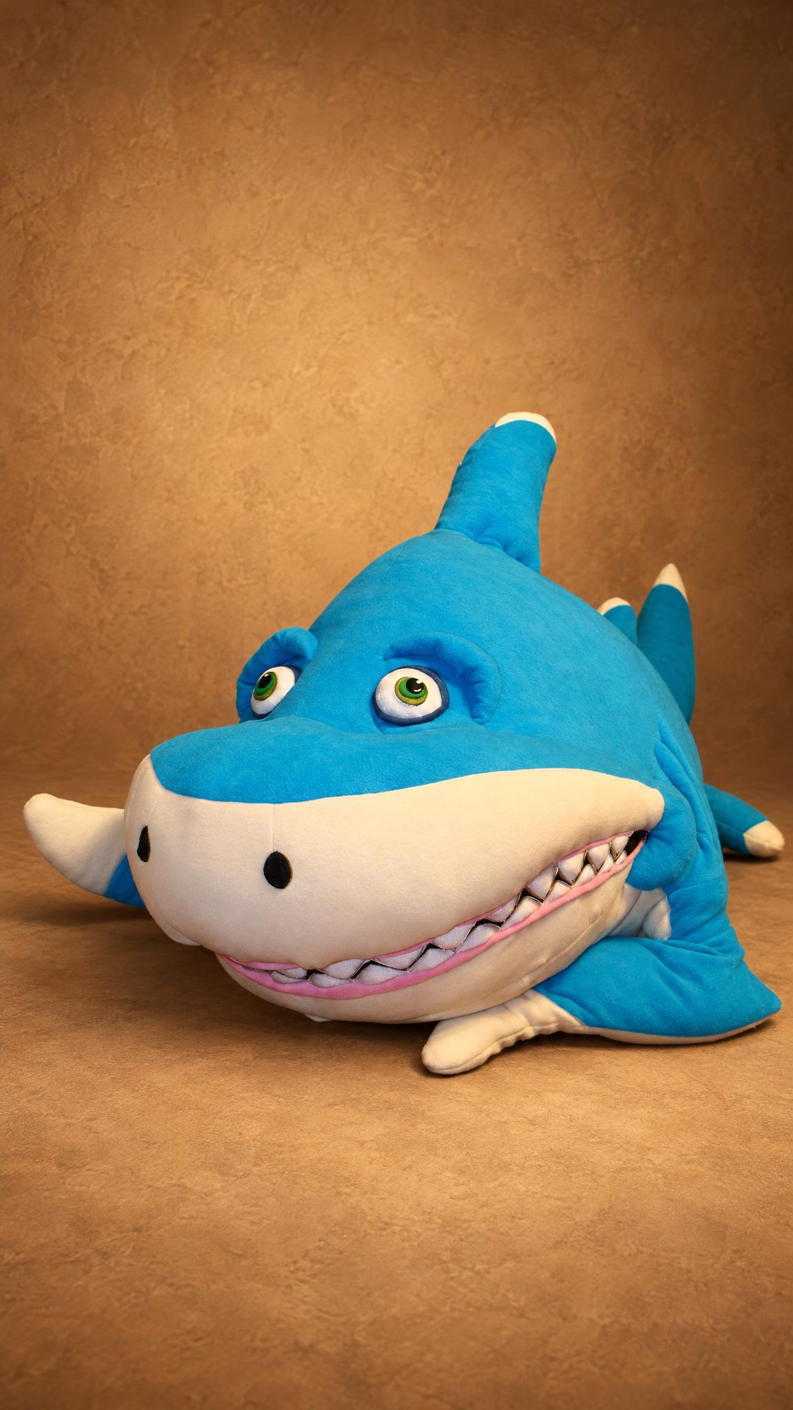 Turquoise giant shark plush with green eyes and white fabric teeth, custom made after the SeeFood film