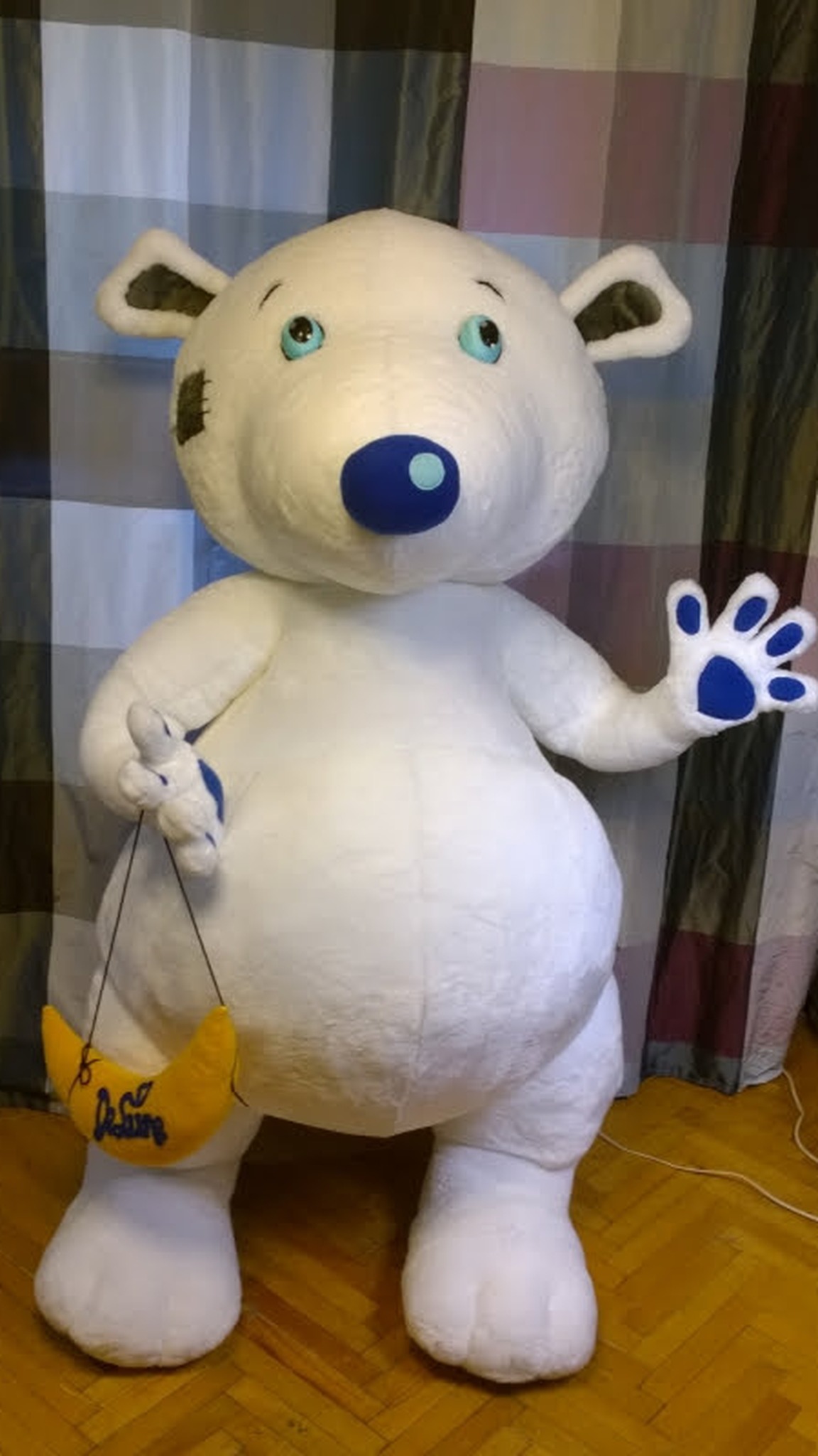 Giant teddy bear mascot in our workshop, white plush bear holding a crescent moon, sewn to order for a brand