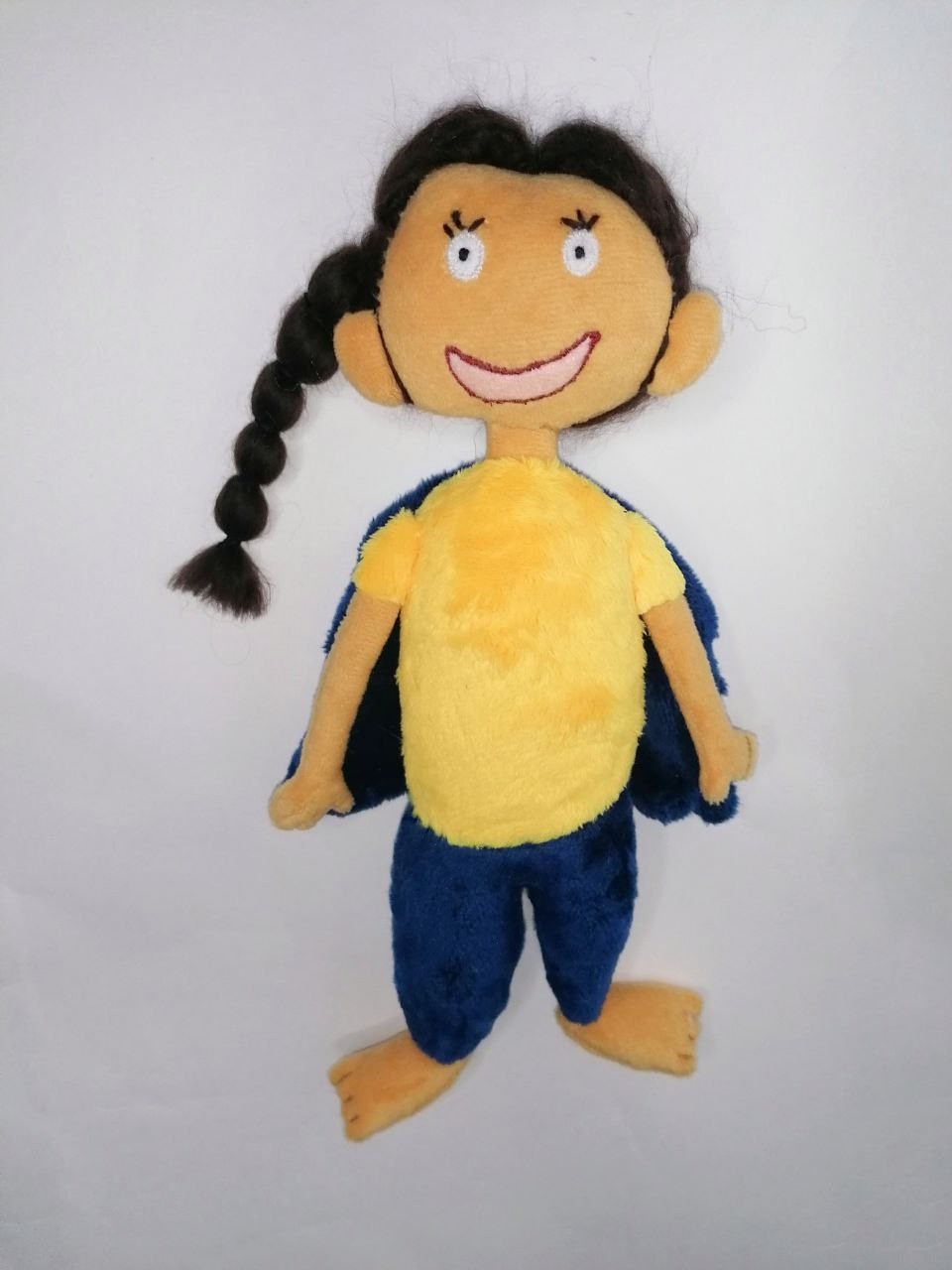 Girl doll from a kid’s drawing Girl doll from a kid's drawing with a yarn braid, yellow T-shirt and navy cape, handmade to order