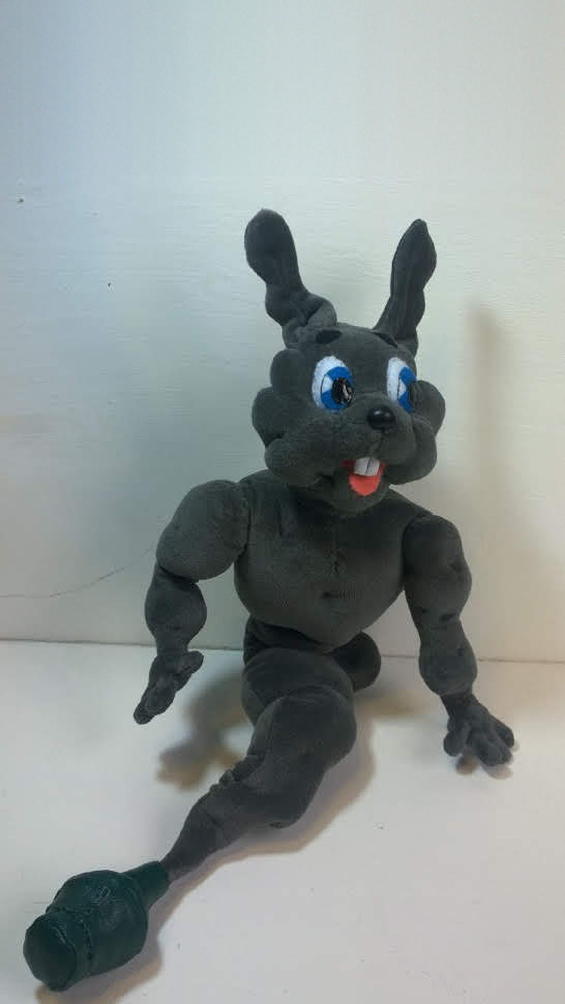 Bunny genie plush in grey with long ears and a pink tongue, tail ending in a dark green bottle, custom made