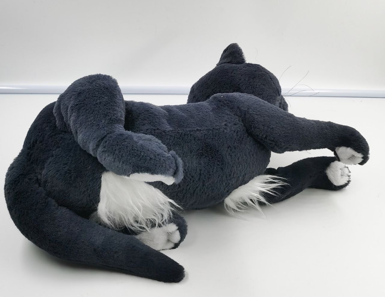 Grey cat plush with a white belly patch Grey cat plush made to order lying on its back, white belly patch and white toe tips on its paws