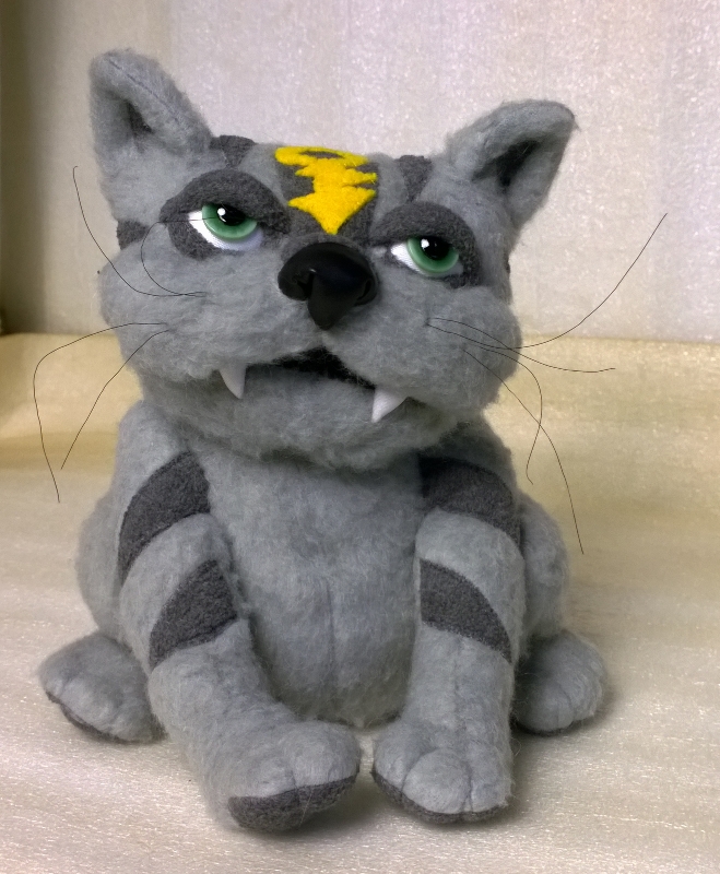 Grey cat plush with fangs and green eyes Custom grey cat plush with heavy-lidded green eyes, white fangs and dark stripes, sewn to order from a drawing