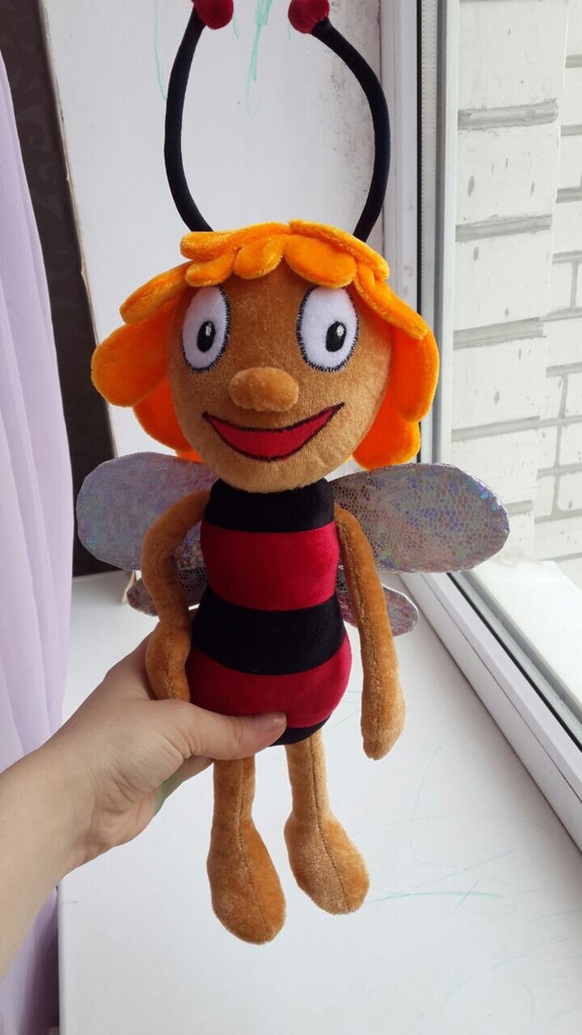 Handmade bee plush with embroidered eyes, a wide red smile and holographic wings, a custom toy from a drawing