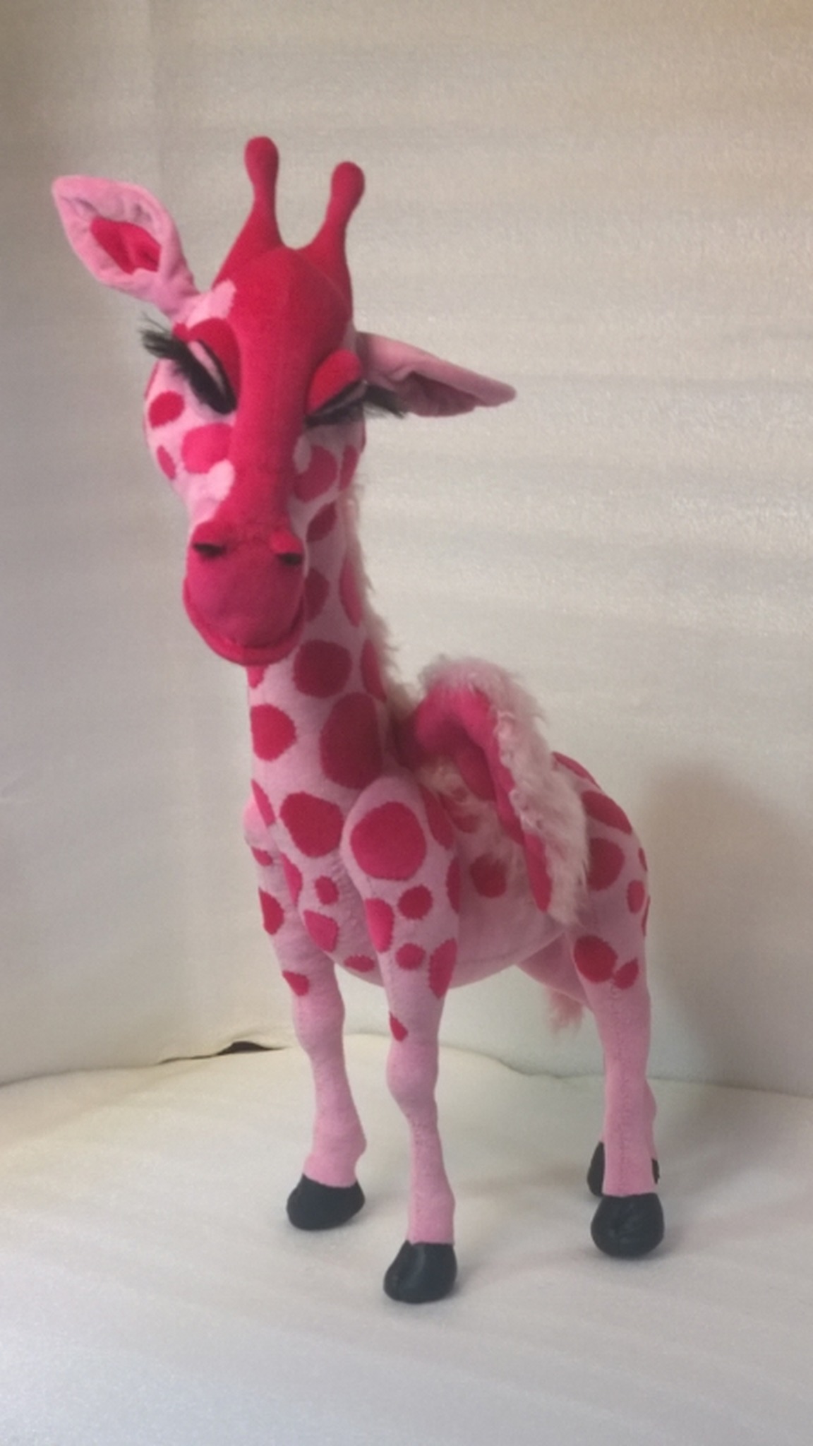 Handmade pink giraffe plush made to order from a drawing, head tilted with long lashes and pink ears