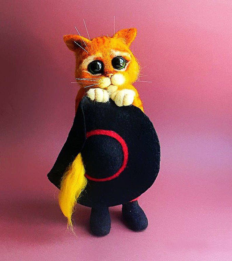 Puss in Boots felted cat with his hat Handmade Puss in Boots felted cat holding his black hat with a yellow plume, big green eyes, custom made
