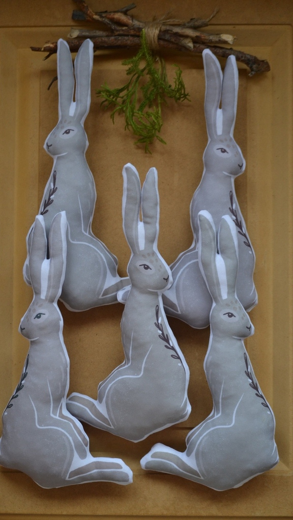 Row of sitting gray hare plush pillows from one small run, custom shaped and sewn to order for a brand