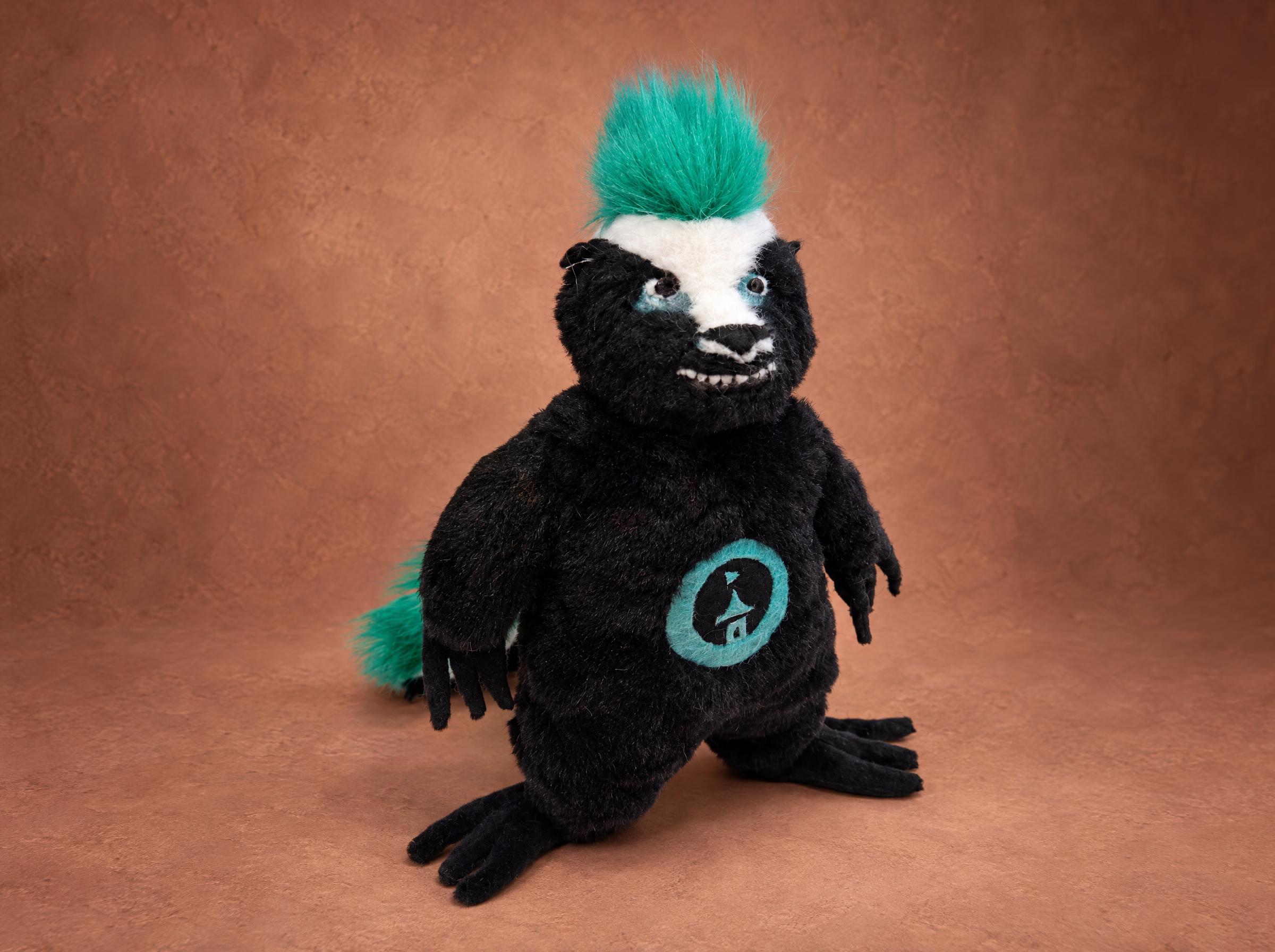 Honey badger plush mascot with a teal mohawk and a logo patch on the belly, handmade to order for a company