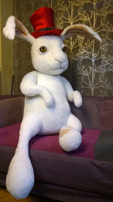 Large rabbit stuffed animal in a top hat Large rabbit stuffed animal sewn to order, sitting on a sofa with legs hanging over, red top hat, amber eyes
