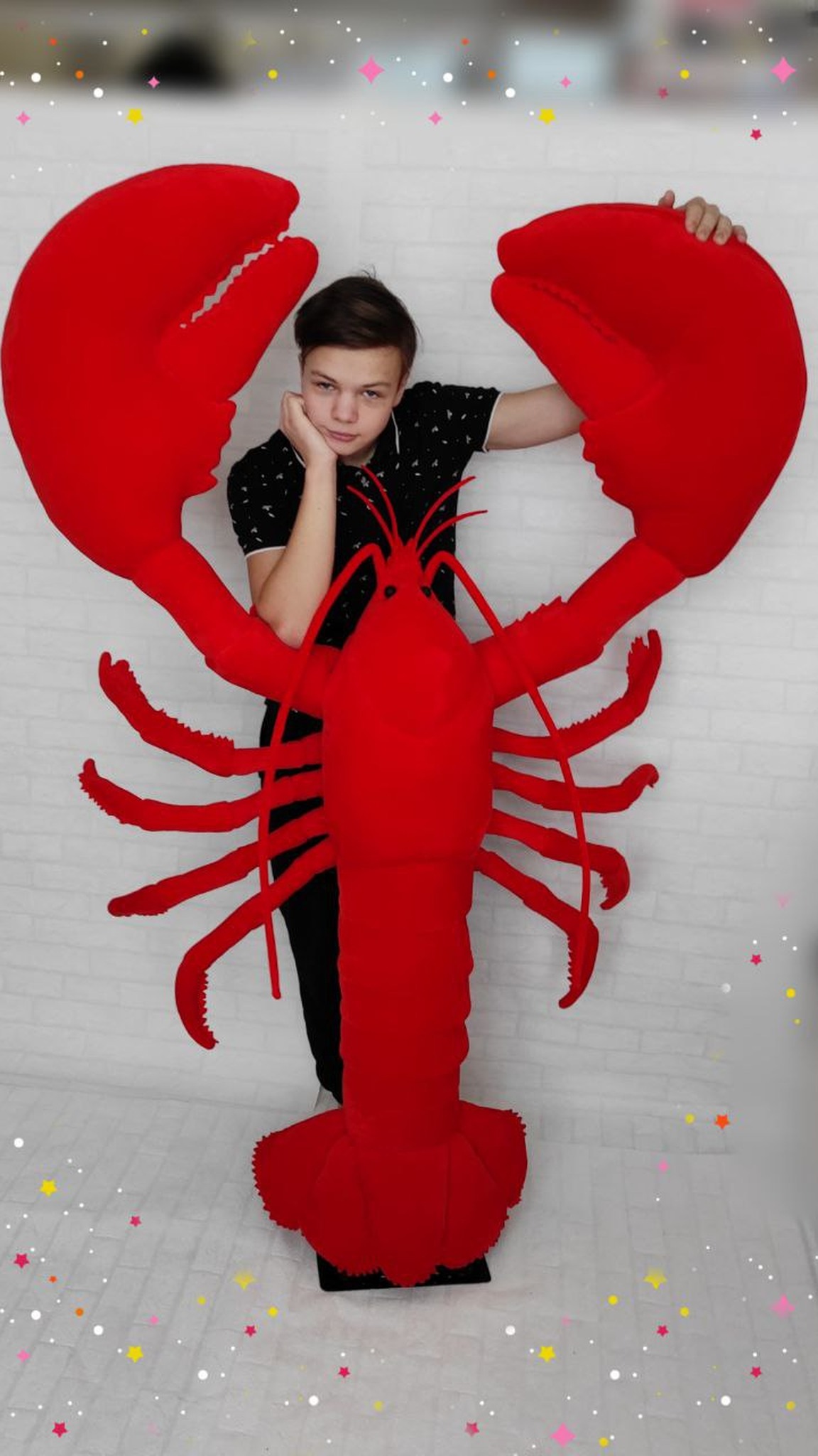 Life-size lobster plush mascot with a teenager standing between its claws for scale, custom made for a bar