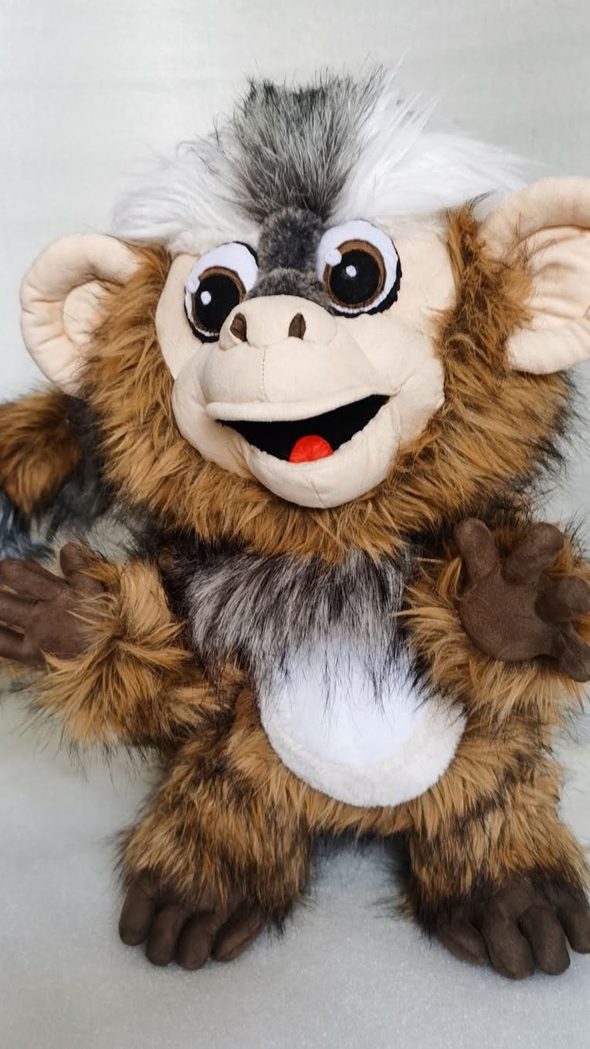Marmoset plush with big cartoon eyes, open grin and a white belly, sewn by hand for one client