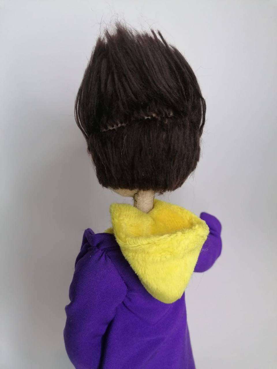Mascot doll hair Dark brown upswept hair of the custom graduate mascot doll above a violet gown, sewn by hand
