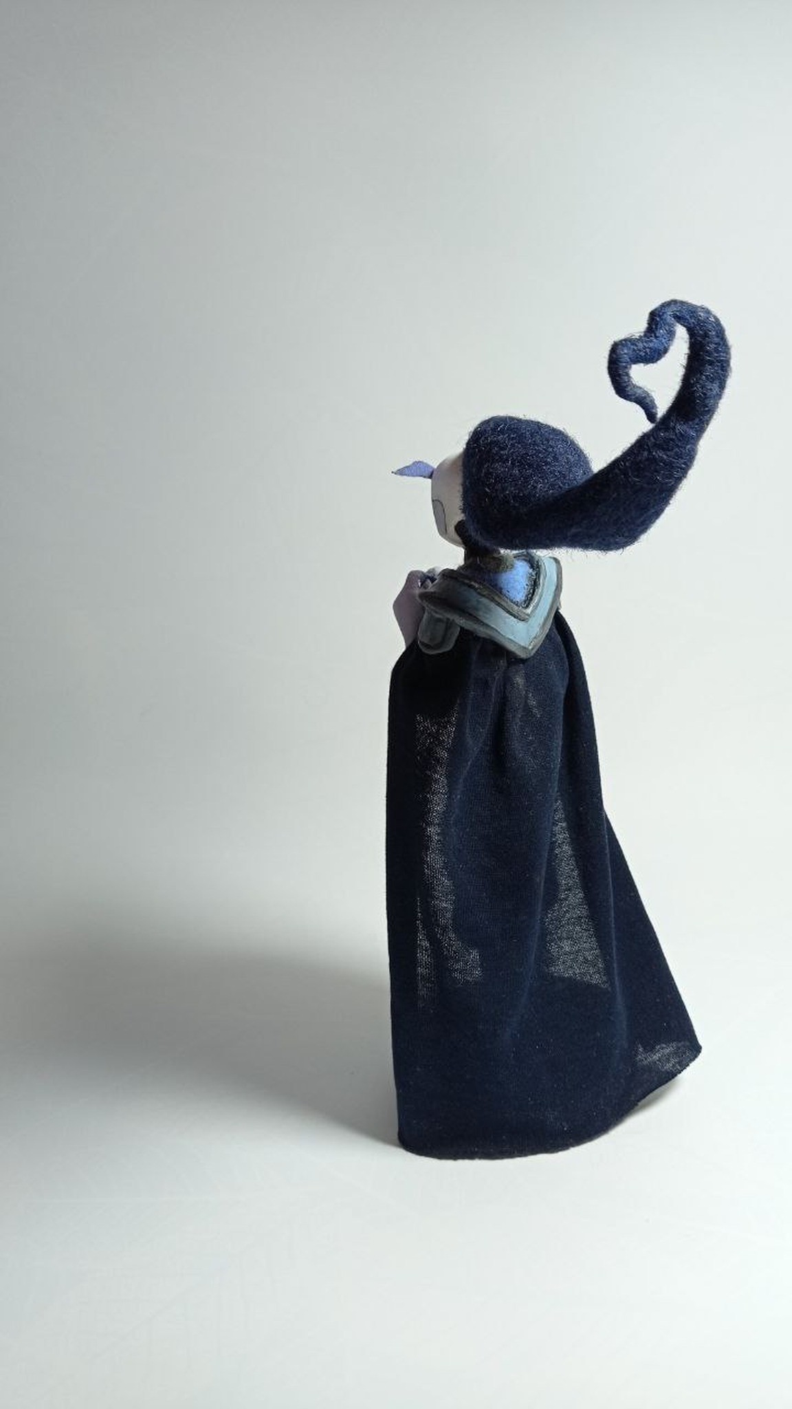 Custom OC doll Midnighter with a dark fabric cape and a felted heart-shaped hair curl, made to order