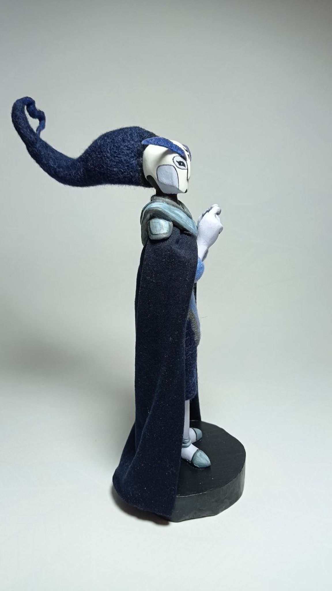 Midnighter custom OC doll with flowing navy wool hair and a fabric cape on a black stand