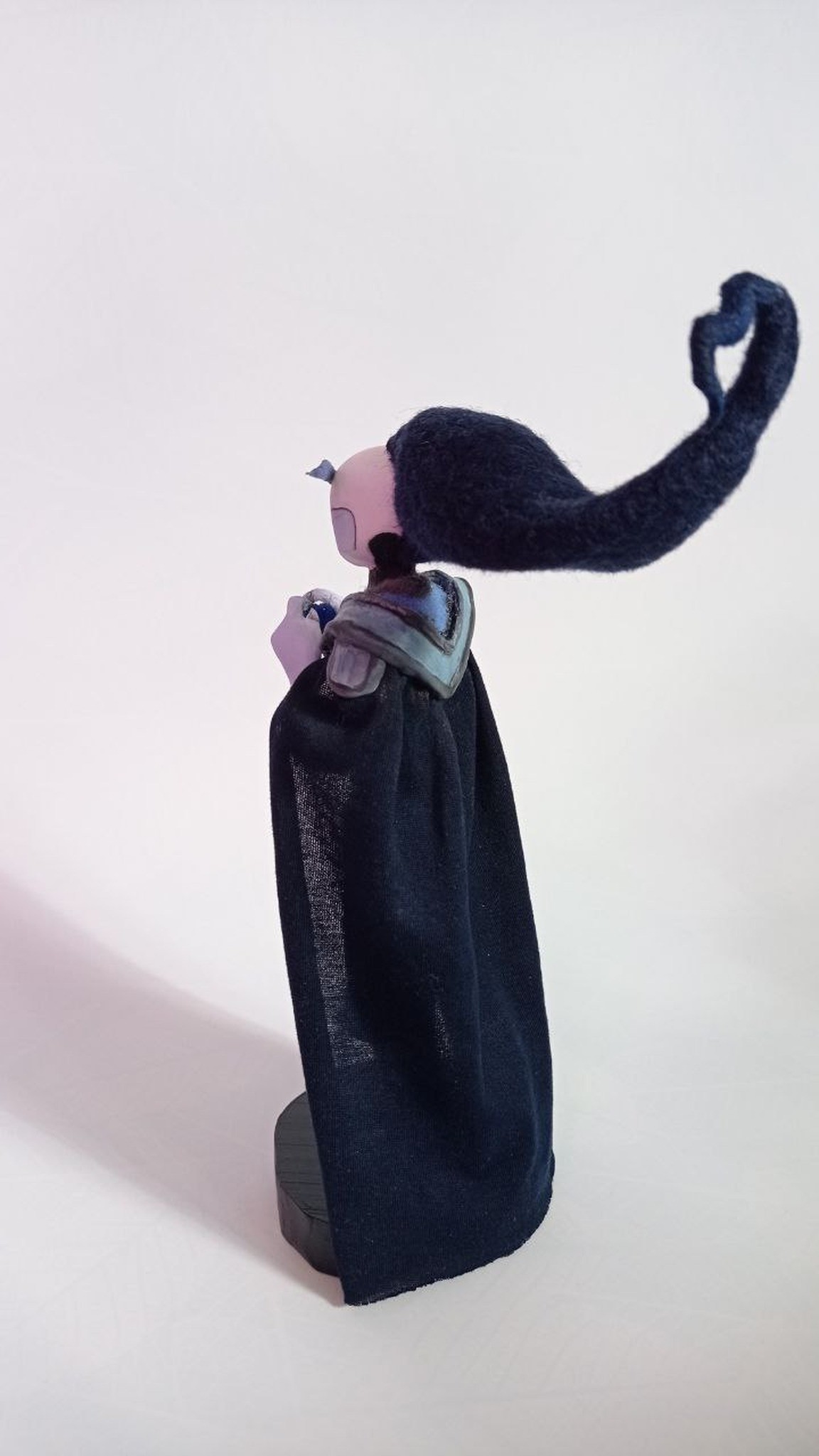 Anime OC doll in a long navy fabric cape with felted hair sweeping back into a heart, made to order