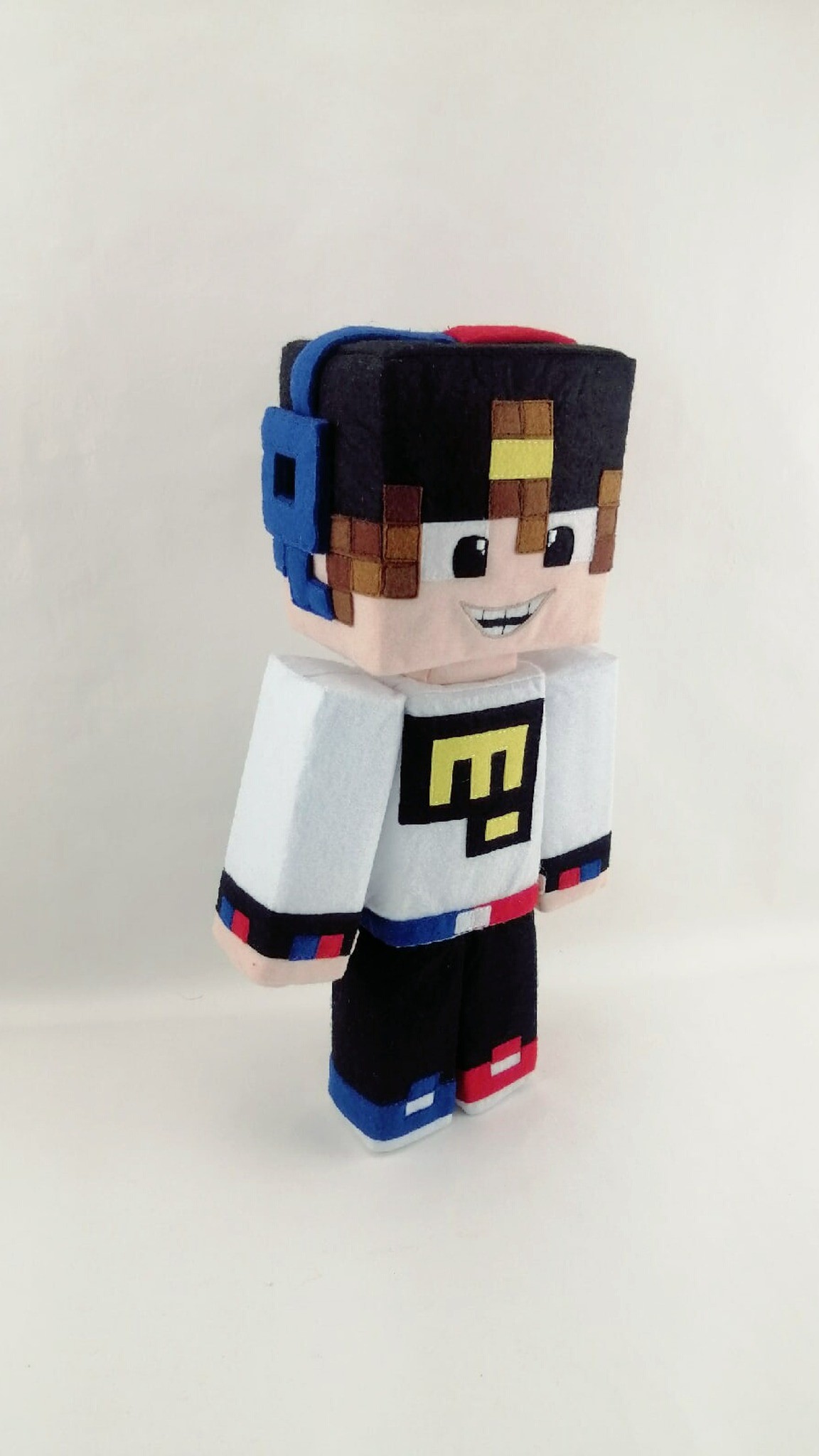 Custom Minecraft plush with yellow pixel logo shirt and tricolor belt, sewn from a fan skin