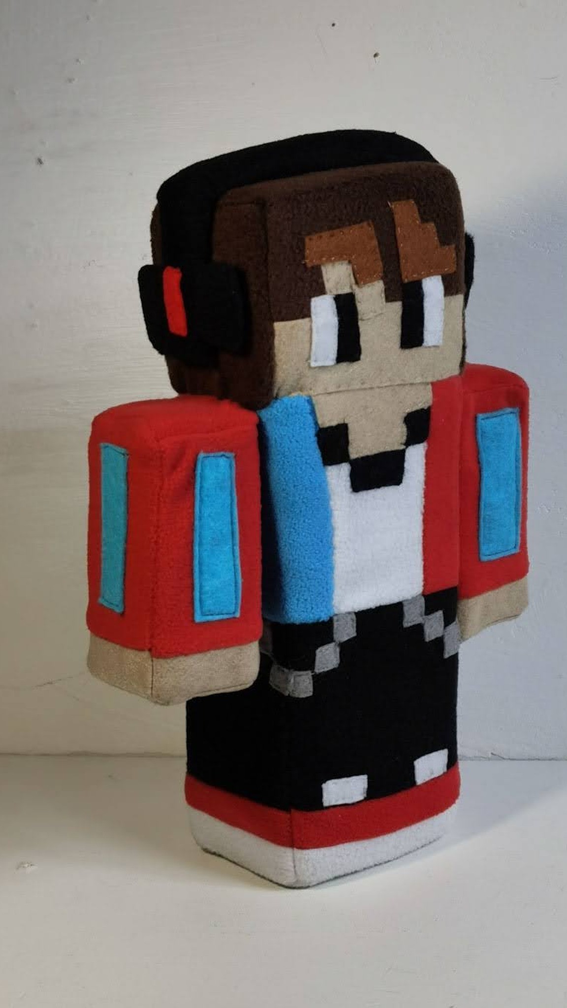 Minecraft YouTuber plush with brown pixel hair and red headphone cups, handmade from a skin