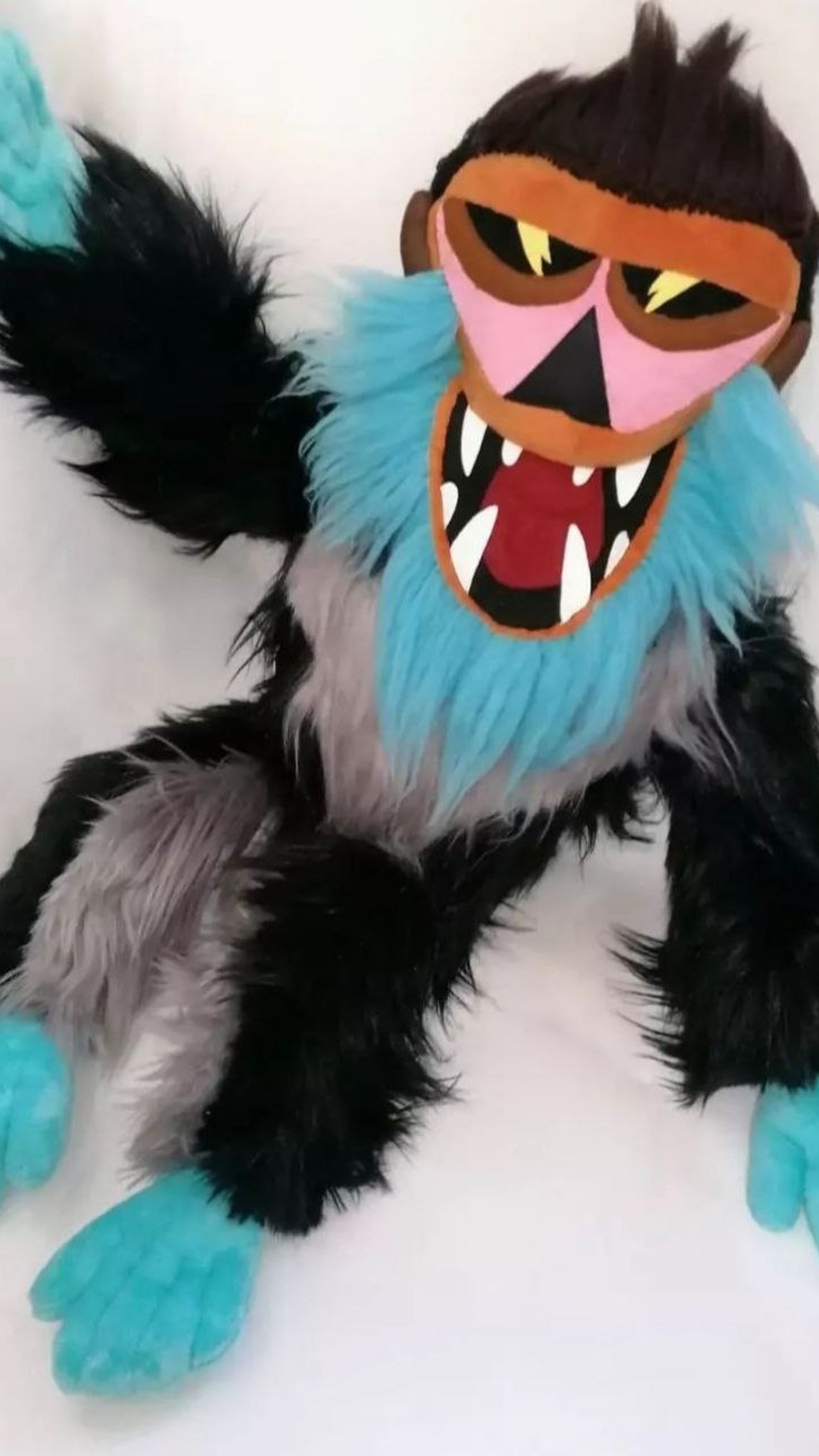 Handmade monkey mascot plush raising a turquoise hand, black and grey faux fur, made to order from a logo
