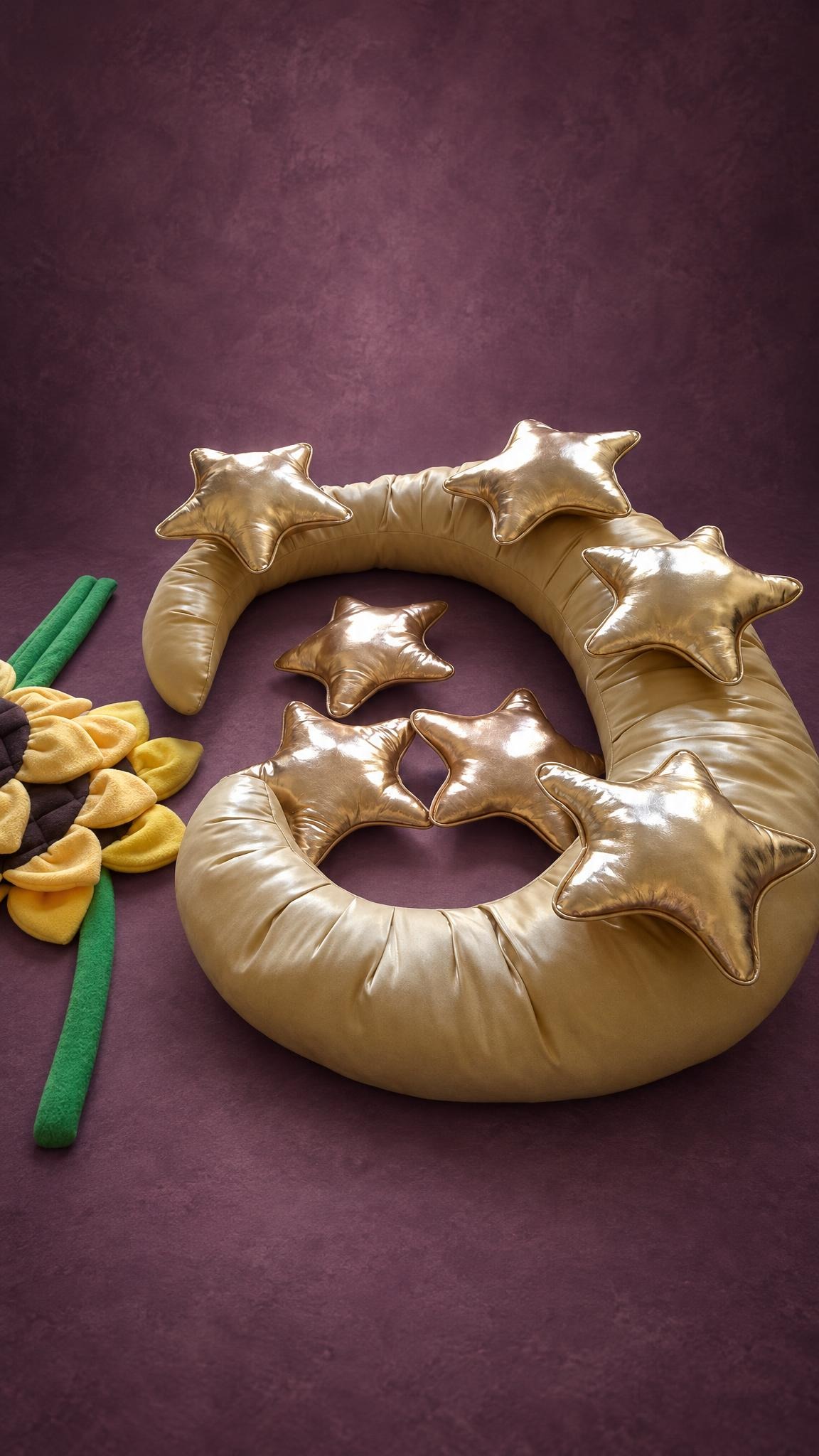 Gold moon pillow photo prop with shiny star cushions and a sunflower, handmade to order for a studio