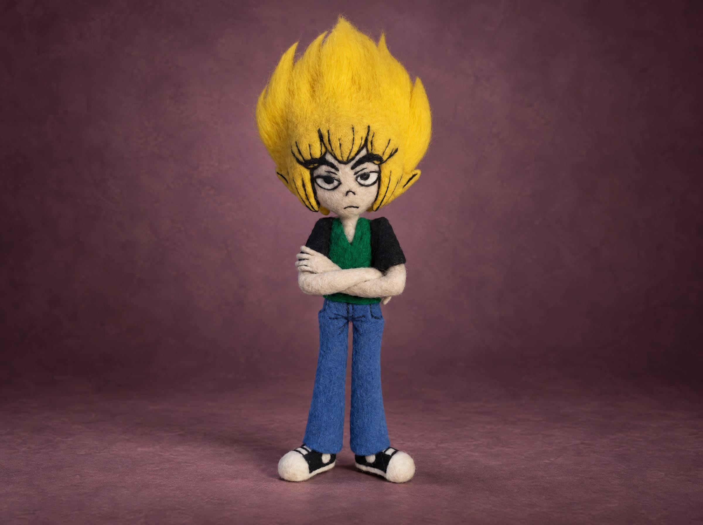 Needle felted anime doll of a grumpy boy with spiky yellow wool hair and crossed arms, made to order