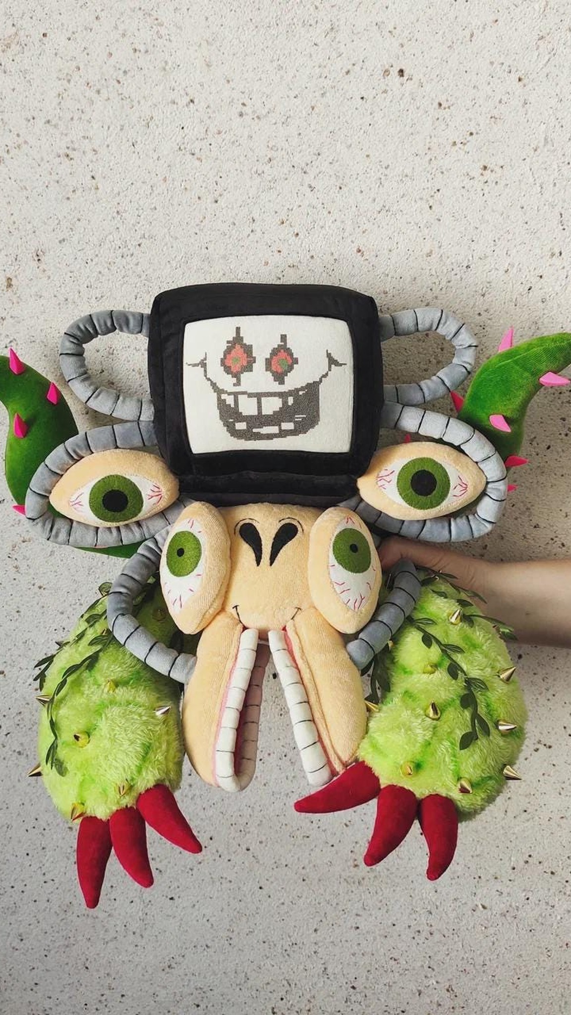 Omega Flowey plush held against a wall for size, cactus arms with red claws, an Undertale plush made to order
