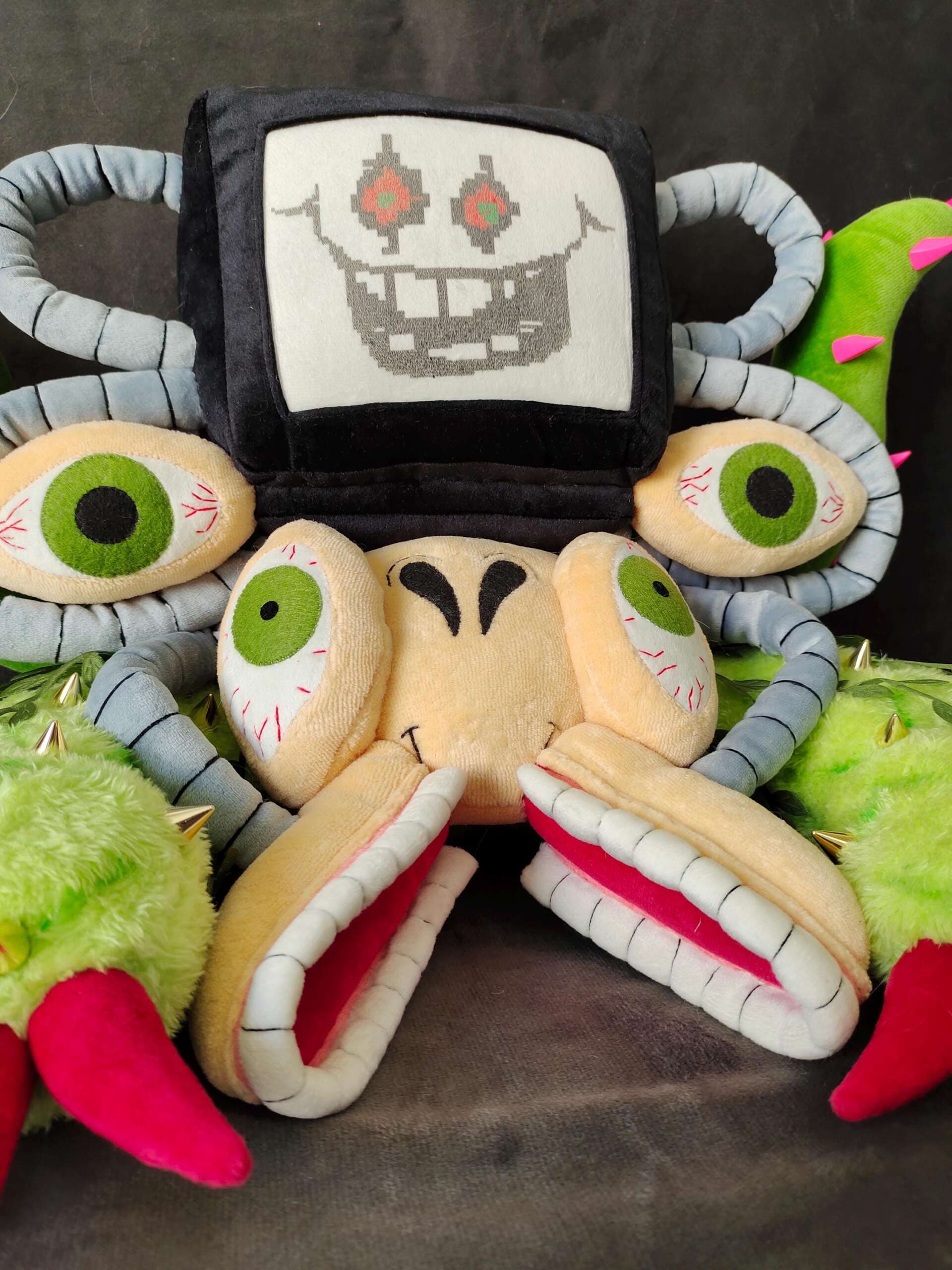 Omega Flowey plush TV face Omega Flowey plush with a cross-stitched TV face, green eyeballs and pink-lined jaws, a custom Undertale plush
