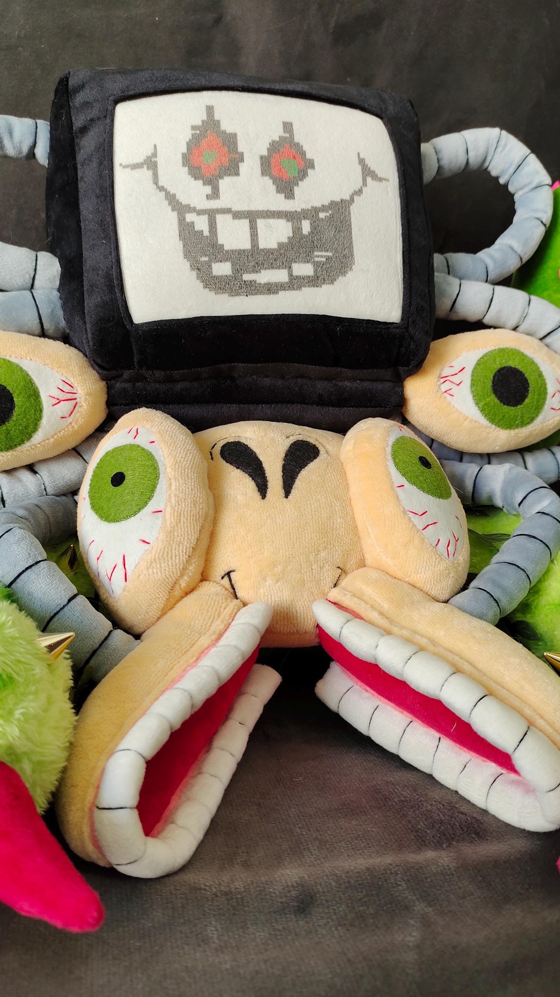 Omega Flowey plush with a cross-stitched TV face, green eyeballs and pink-lined jaws, a custom Undertale plush