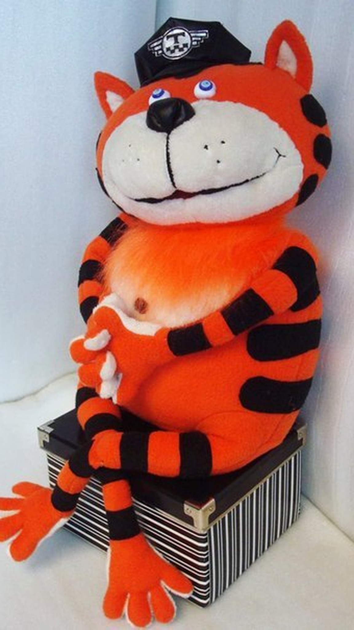 Orange tabby cat plush in a taxi cap sitting on a box, long striped legs hanging down, handmade to order