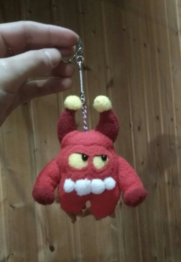 Red Orik custom plush keychain Red Orik custom plush keychain with horns, yellow pom-poms and white teeth, handmade to order from clay