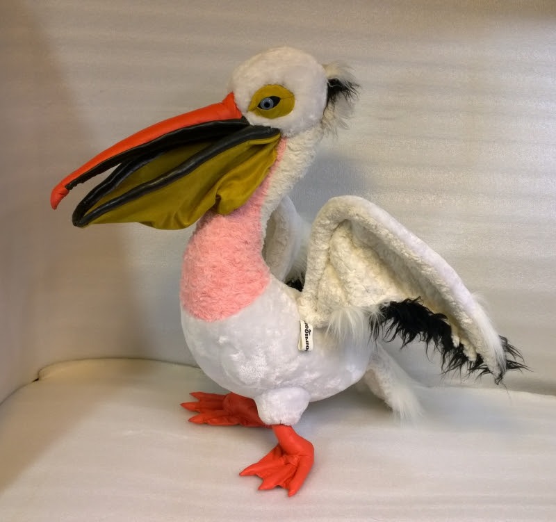 Pelican plush lifting a wing Pelican plush lifting a wing to show black shaggy flight feathers, blue glass eye, handmade to order