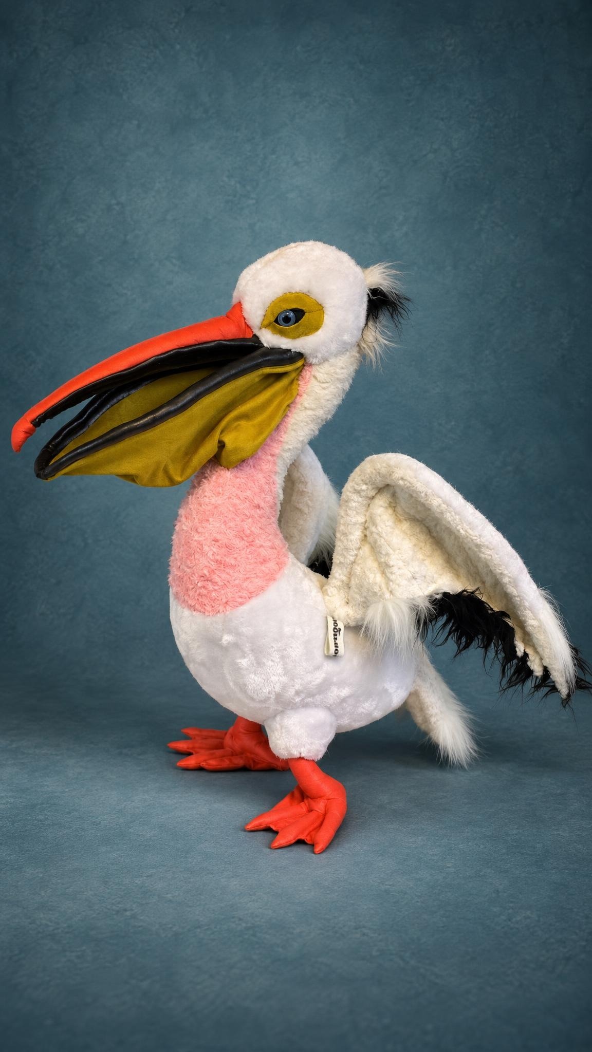 Handmade pelican plush in white faux fur with an orange beak and a big mustard pouch, sewn to order