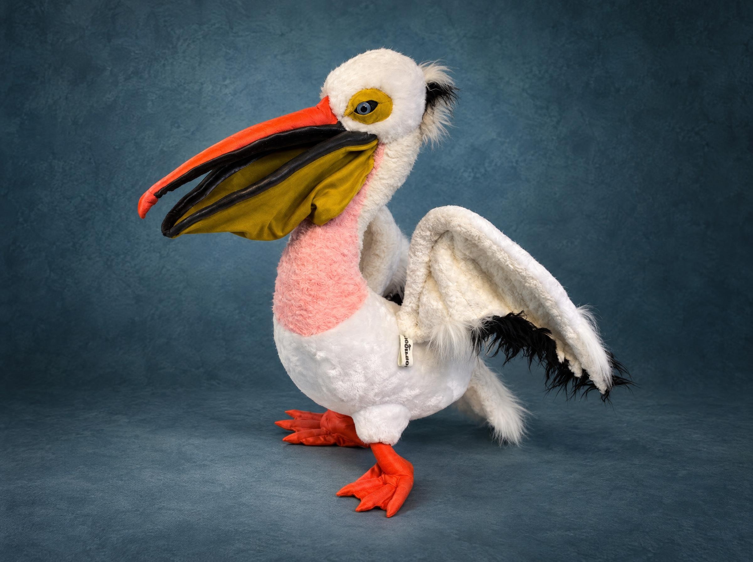 White pelican plush with a pink chest, mustard pouch and orange webbed feet, one wing raised, made to order