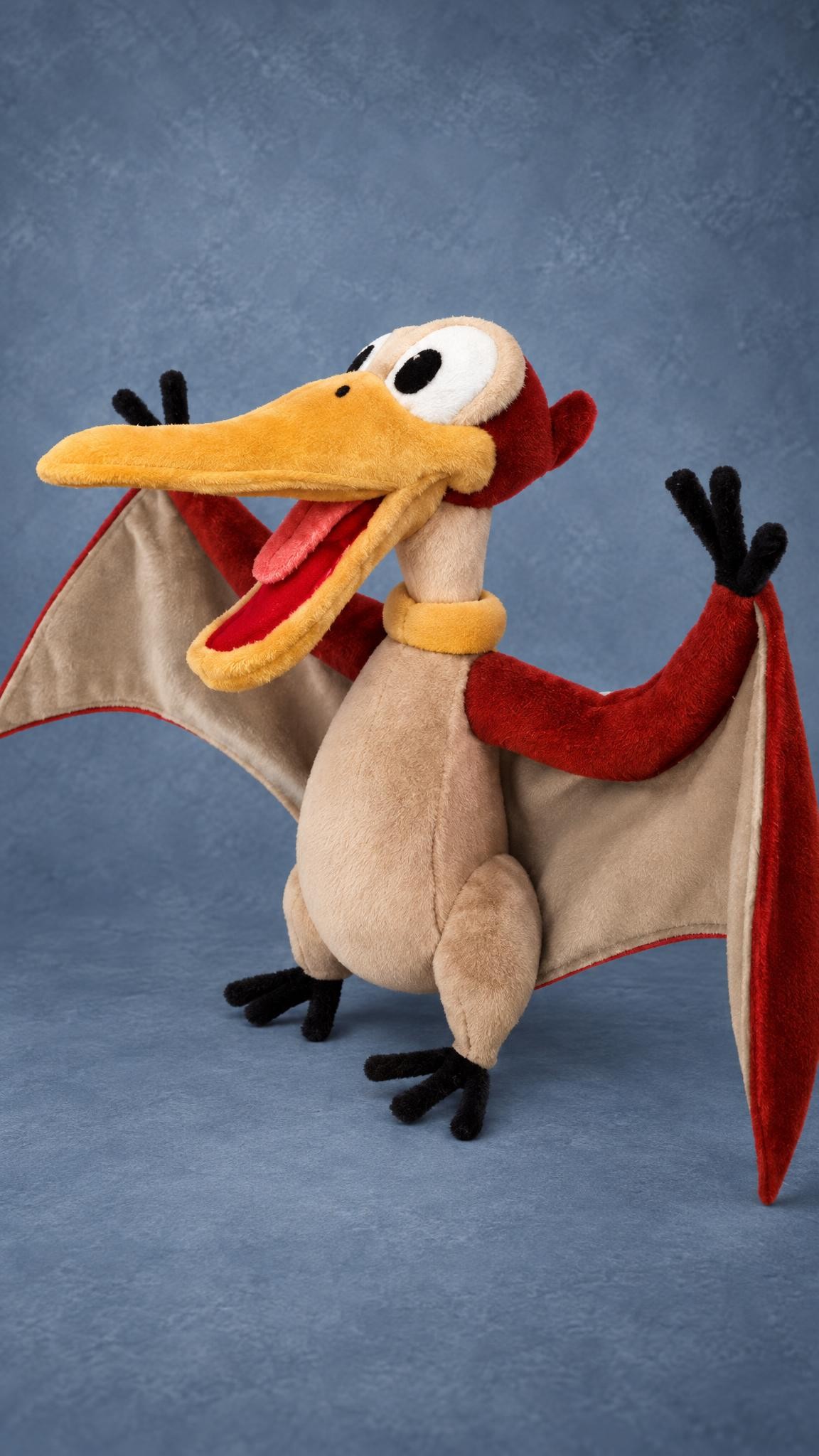 Handmade Petrie plush with big white eyes, a pink tongue and an orange neck ring, sewn to order