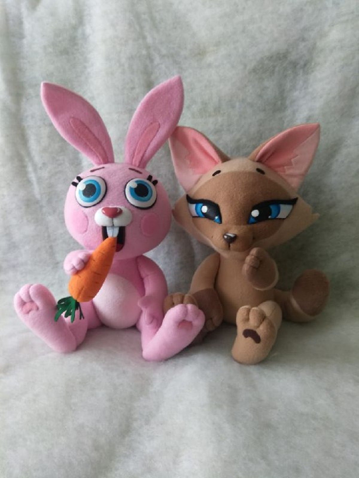 Pink bunny and tan fox sticker plush Pink bunny plush with buck teeth and a carrot next to a tan fox plush with a raised paw, handmade from stickers