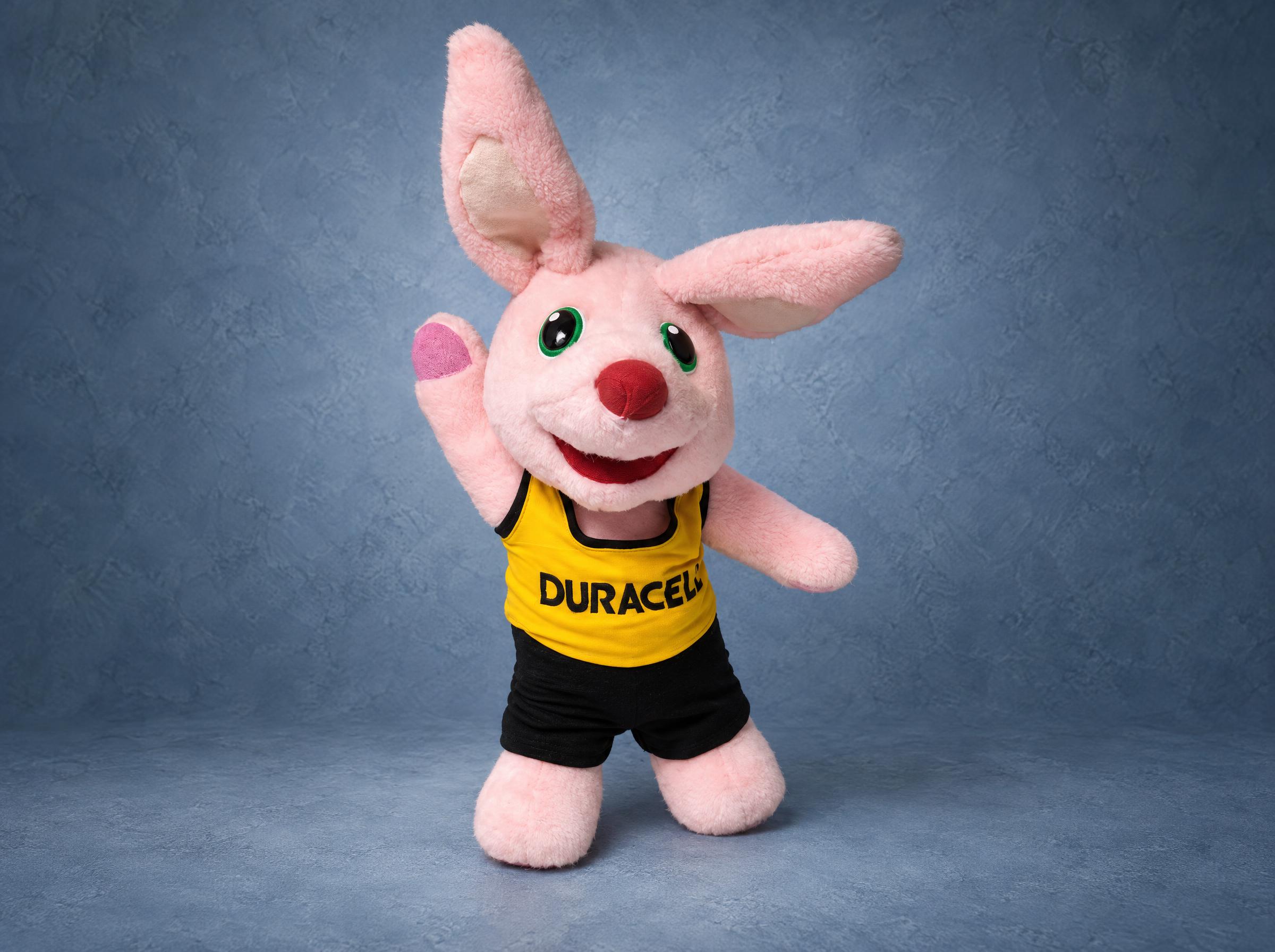Pink bunny mascot plush from a TV battery ad, waving, in a yellow top and black shorts, handmade to order