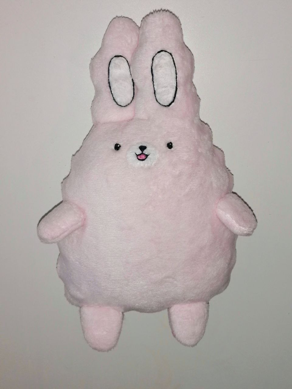 Pink bunny plush from an emoji sticker Pale pink bunny plush made from an emoji sticker, black-stitched ear ovals and a tiny pink mouth, custom made