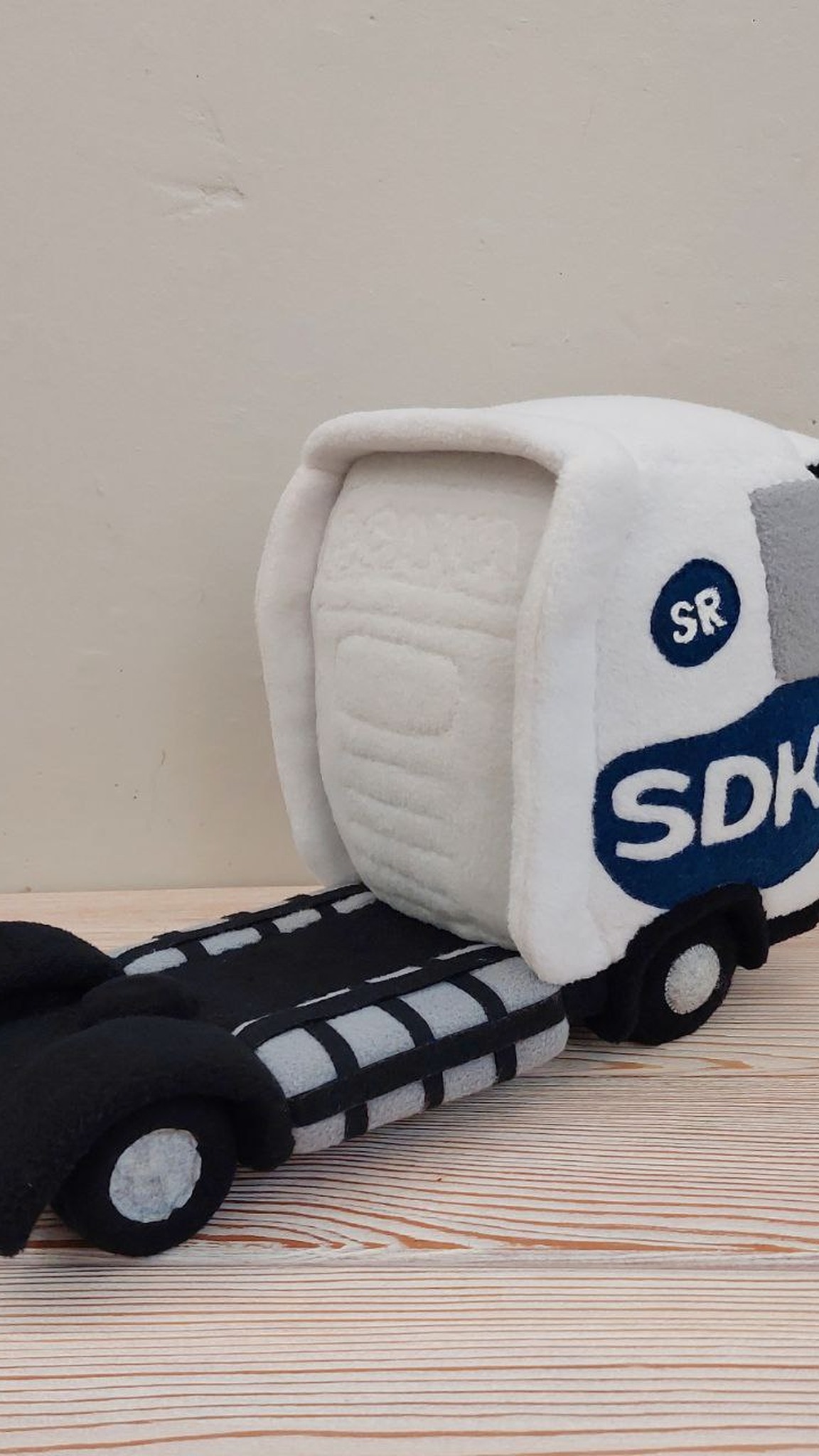 White plush truck cab with company logo on the door and soft wheels, a branded toy made to order
