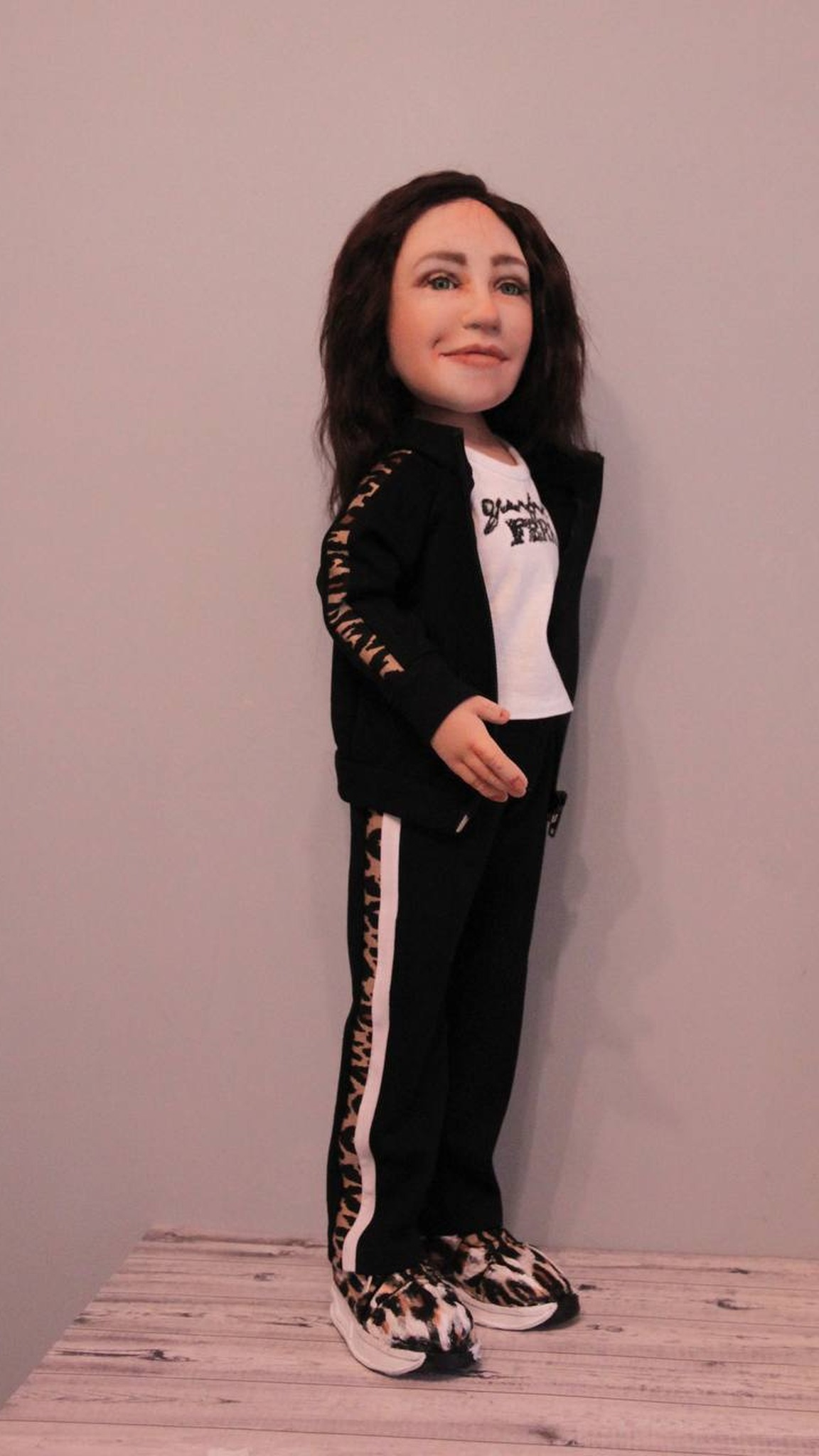 Handmade portrait doll of a woman: black track pants with white and leopard stripes, leopard-print sneakers