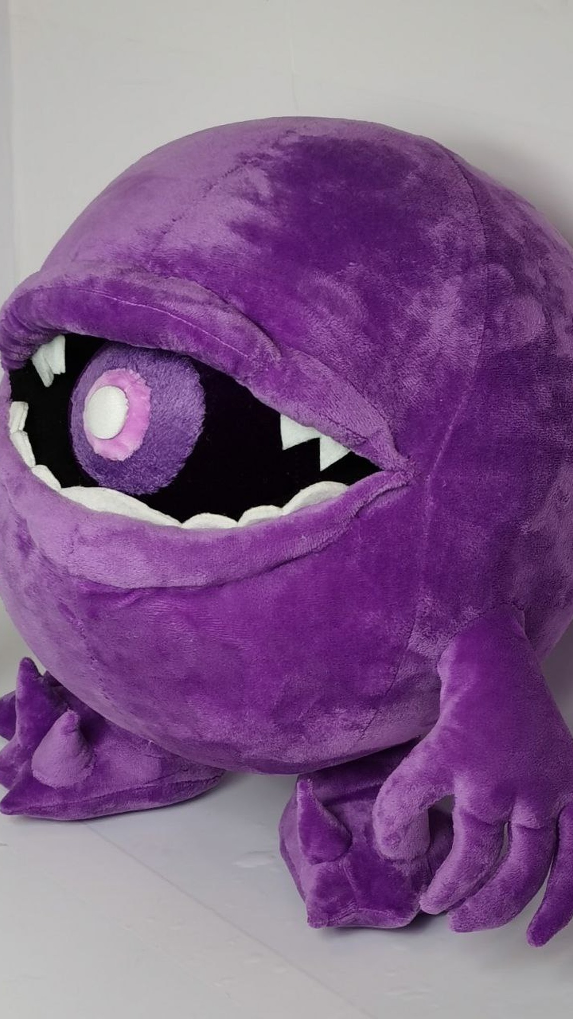 Round purple monster plush with a pink-and-white ball in its mouth, sewn to order from a child's drawing
