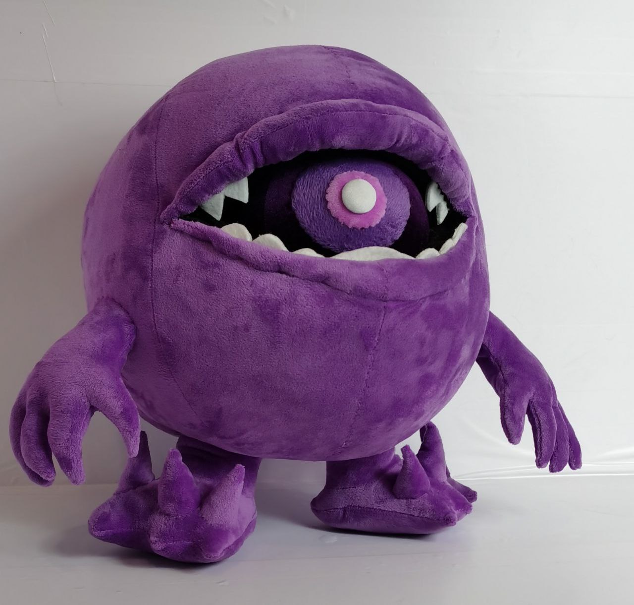 Purple monster plush with white teeth Purple monster plush Fiobol with an open mouth, white pointed teeth and a dark inside, handmade custom plush