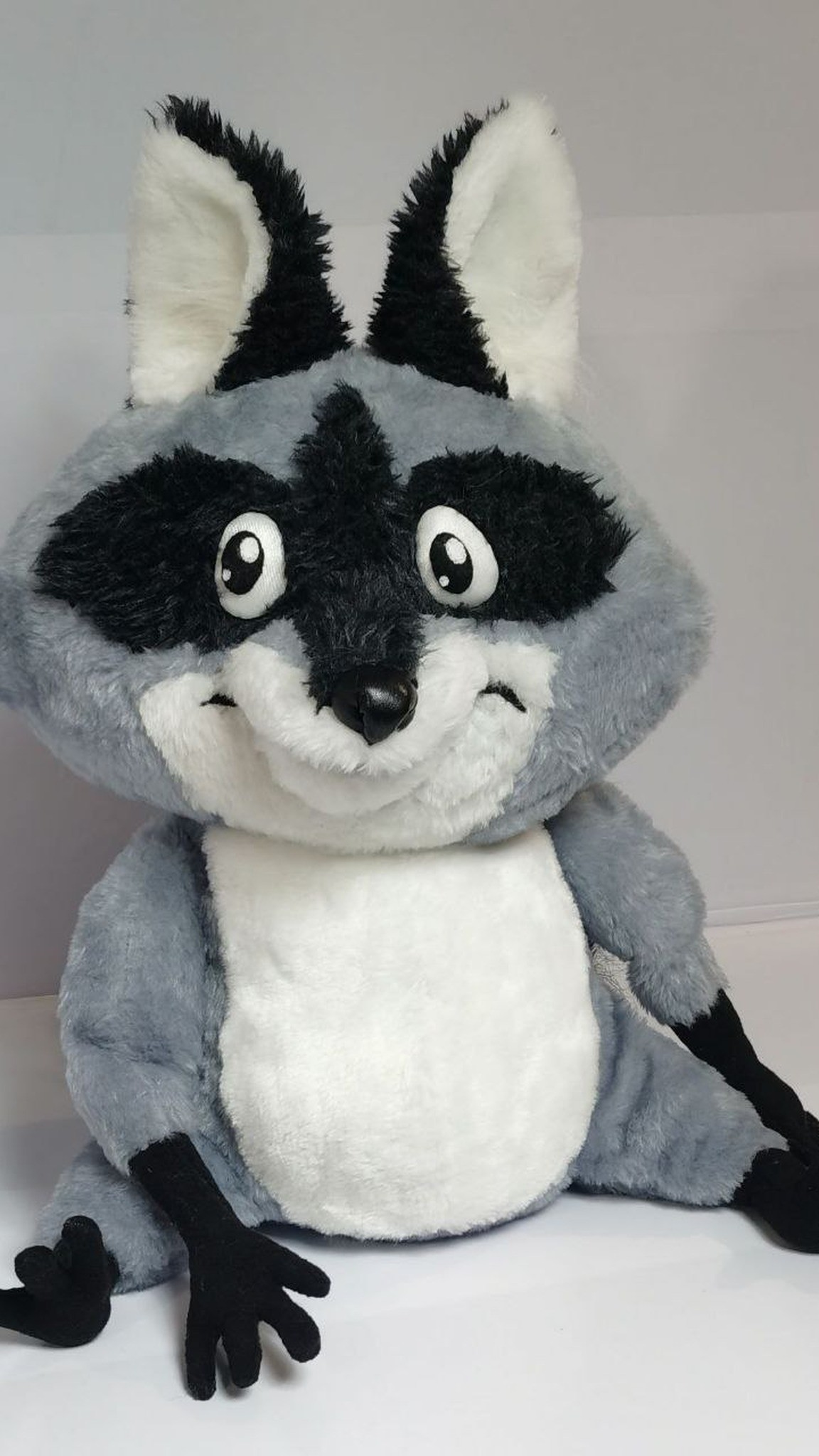 Custom raccoon plush with a half smile, long black fingers and white belly, made to order