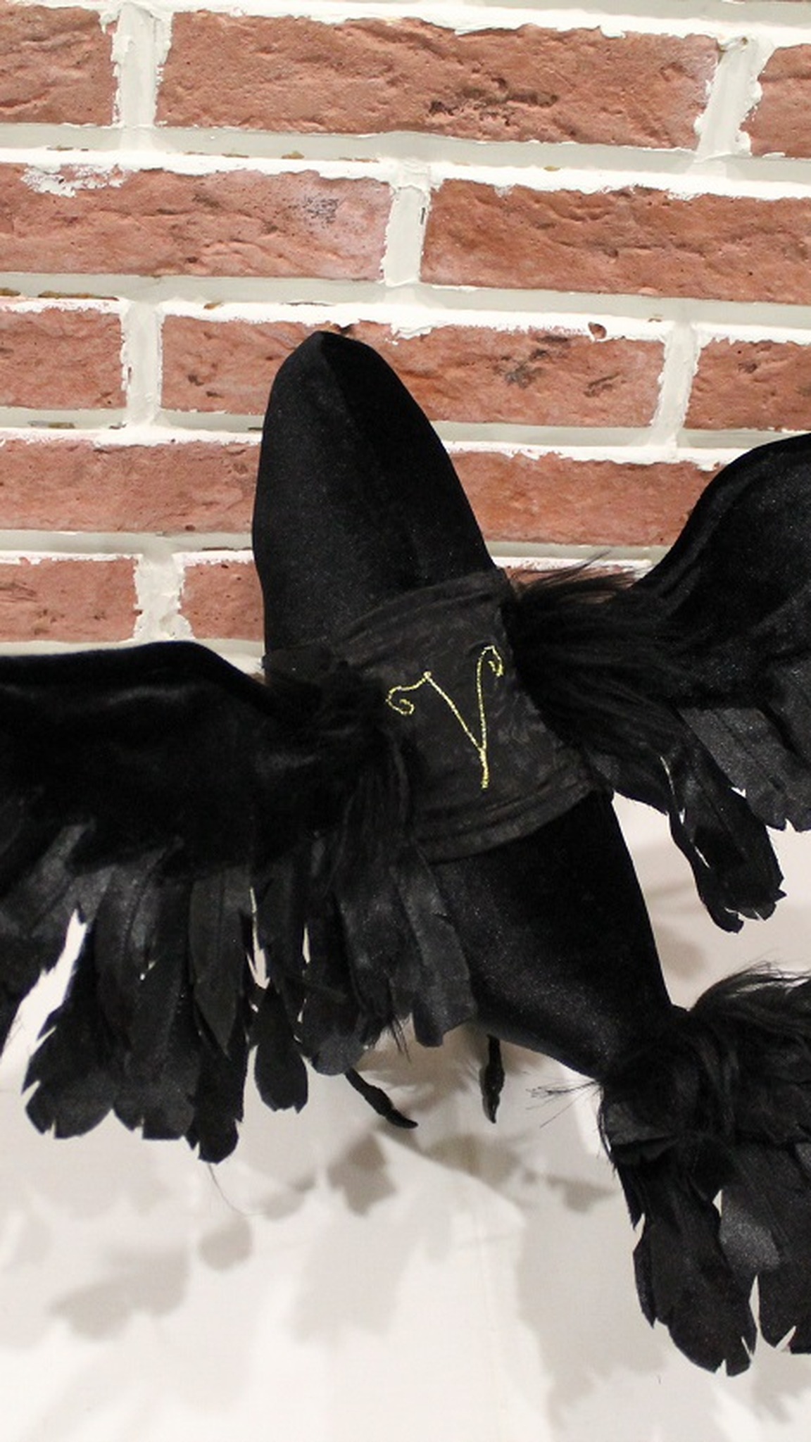 Raven plush with open wings and a gold initial on its velvet vest, a custom poseable bird made to order