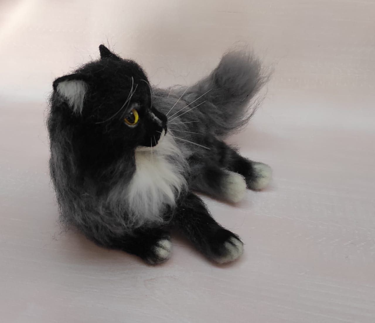 Fluffy cat plush turning its head Fluffy cat plush turning its black head over a smoky grey shoulder, sewn by hand to order