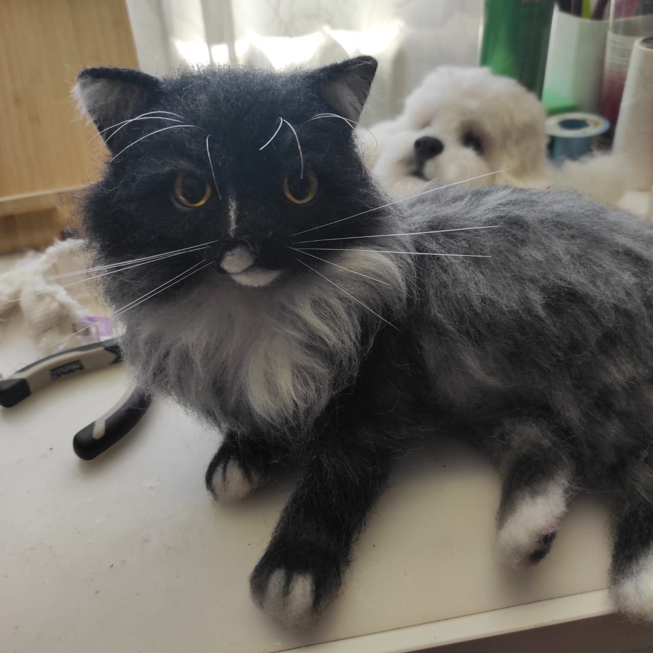 Realistic fluffy cat plush in the studio Realistic fluffy cat plush on the work table in our studio, white bib and amber eyes, made to order