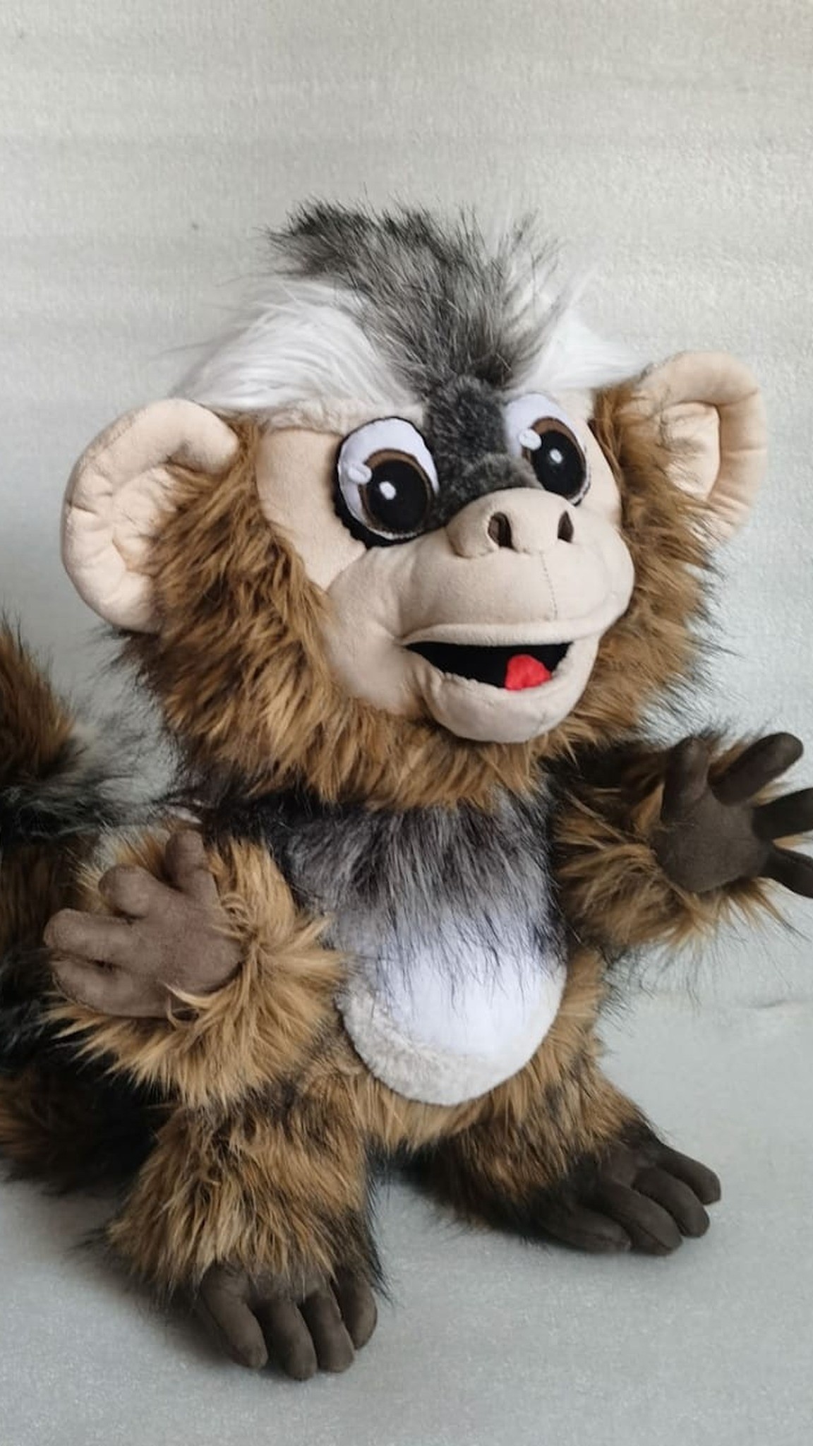 Marmoset monkey plush with a striped tail curled behind and a hand on its belly, sewn to order