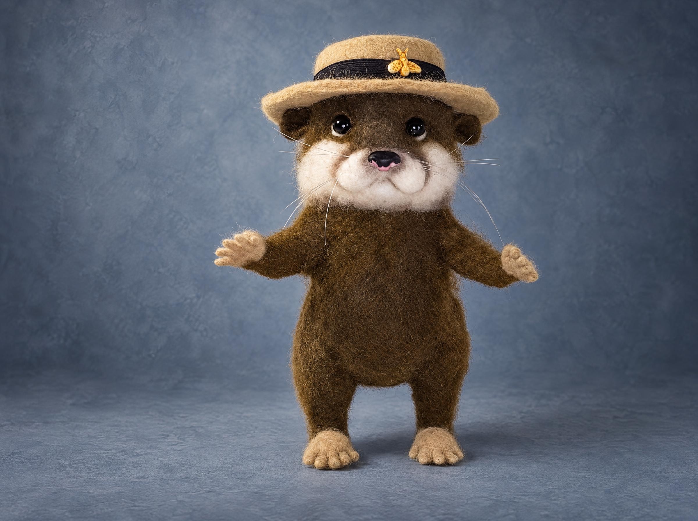 Realistic otter plush in felted wool with a beige boater and gold bee, paws spread wide, made to order