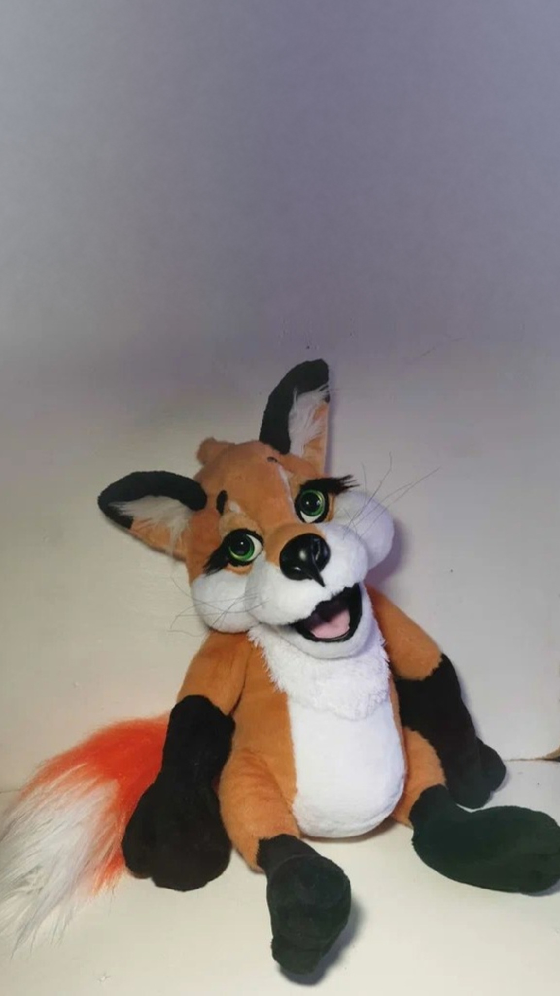 Red fox plush with his head tilted and one black ear flopped, a custom toy sewn to order from a drawing